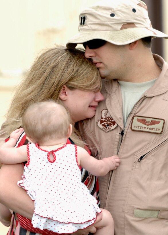 Capt. Steven Fowler, 34th Bomb Squadron weapons system operator, hugs his wife, Cara, and seven-month-old daughter Makenna here July 22.  Captain Fowler is deploying to Southwest Asia. (U.S. Air Force photo/Airman Matthew Flynn)

