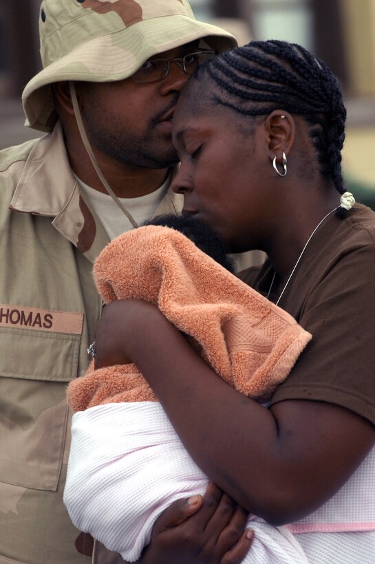 Staff Sgt. Johnathan Thomas, 28th Aircraft Maintenance Squadron aircraft hydraulic systems journeyman, kisses his wife, Alicia, farewell before deploying to Southwest Asia from Ellsworth July 22. While deployed, Sergeant Thomas will maintain combat readiness of B-1B Lancers. (U.S. Air Force photo/Airman First Class Adam Grant) 