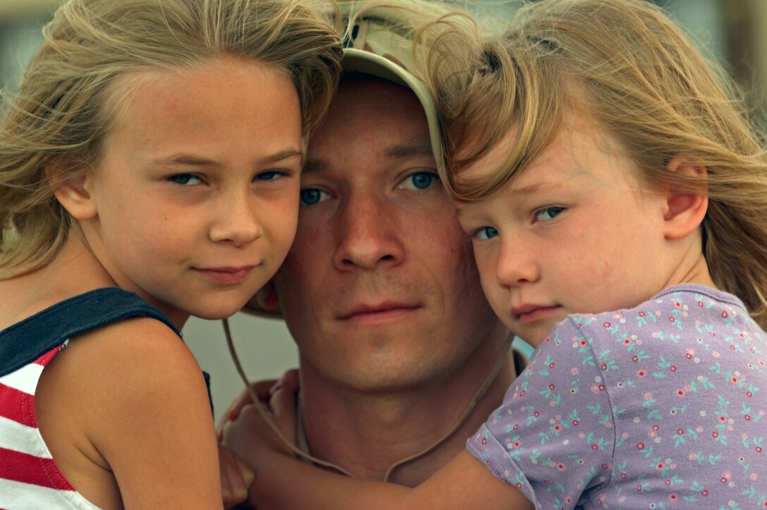 First Lt. William Jacks, 34th Bomb Squadron pilot, bids farewell to his daughters, (left) Anna and Rachel, before deploying to Southwest Asia from Ellsworth July 22. Deployed Ellsworth Airmen will provide rapid, decisive and sustainable combat airpower for global defense.  (U.S. Air Force photo/Airman First Class Adam Grant)