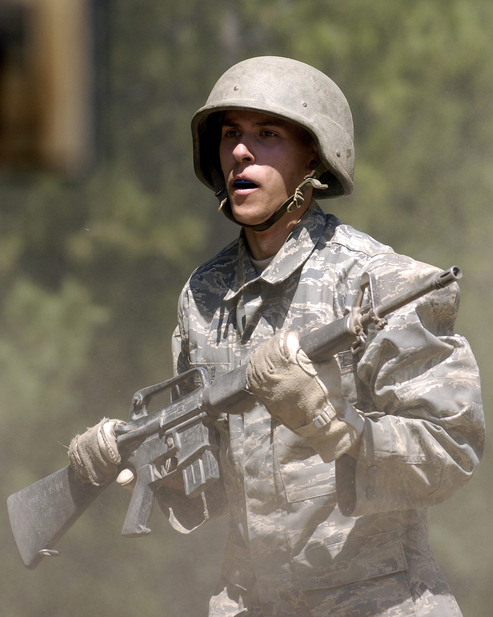 U.S. Air Force Academy Basic Cadet Stephen Pineo runs the assault course in a cloud of dust July 16 during the field training portion of basic training at the Jacks Valley training area near Colorado Springs, Colo.  (U.S. Air Force photo/Mike Kaplan)