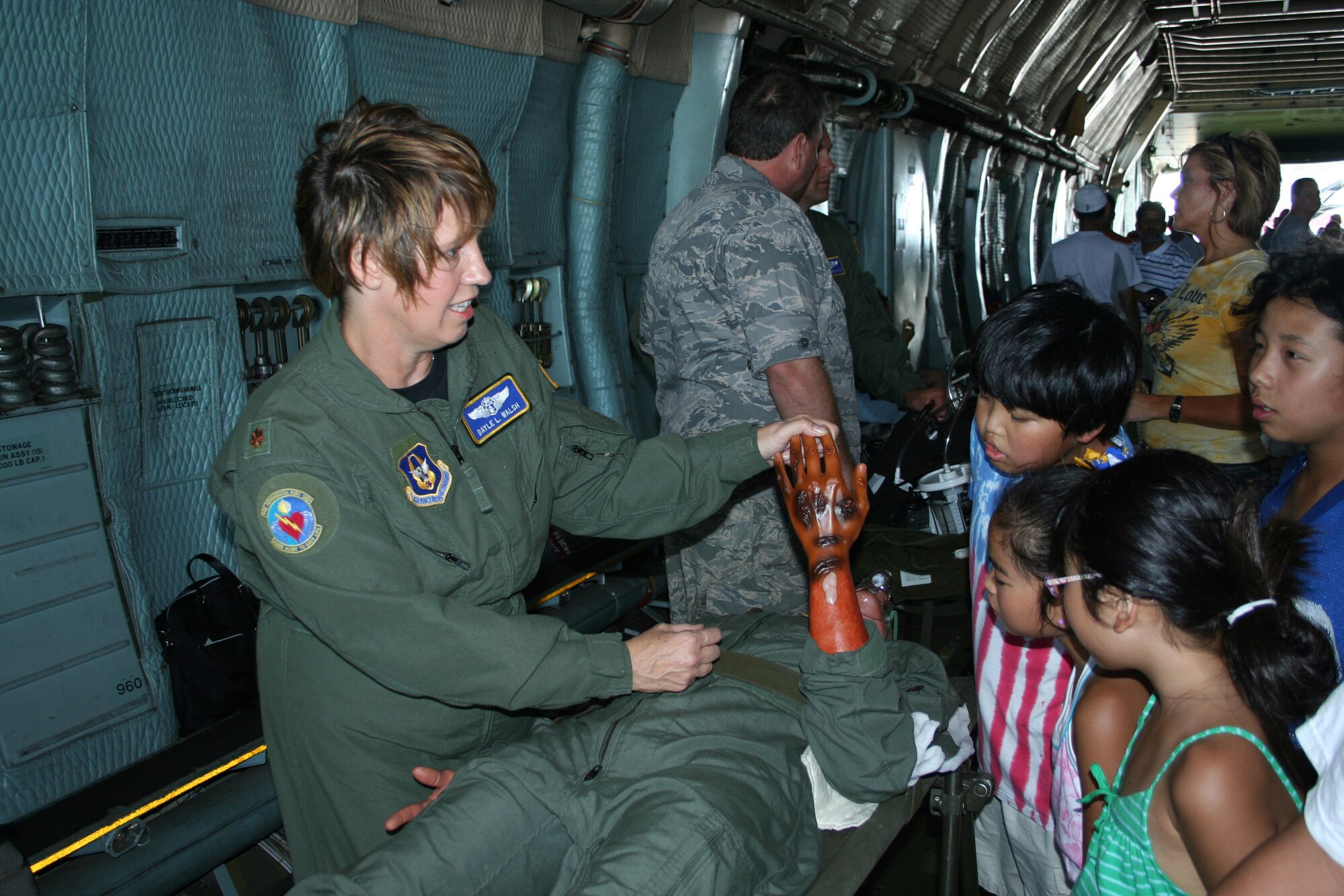 WRIGHT-PATTERSON AFB, Ohio - Maj. Dayle Lynn Walsh, 445th Aeromedical Evacuation Squadron, demonstrates care patients would receive in flight with mannequins on litters to visitors at the Dayton Airshow.  The 445th Aeromedical Evacuation Squadron is one of the largest AES squadrons in the Air Force.  (U.S. Air Force photo/Senior Airman Ken LaRock)