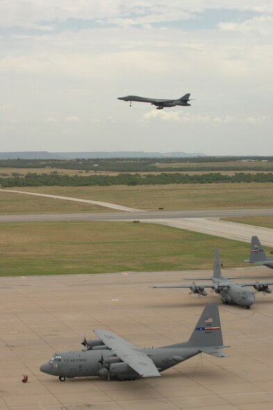DYESS AIR FORCE BASE, Texas -- Two C-130s taxi to their parking spots after a 10-plane formation, as a B-1 flies by July 16.  (U.S. Air Force photo by Senior Airman Jennifer Romig)