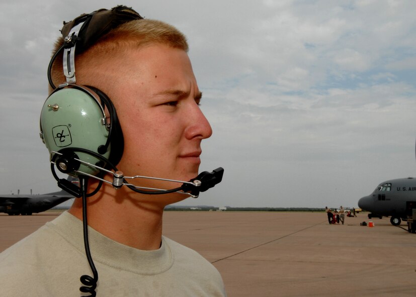 DYESS AIR FORCE BASE, Texas -- Airman 1st Class Daniel Reeder, a 317th crew chief, performs a sound check on the C-130 headsets July 16.  Airman Reeder along with many more C-130 crew chiefs participated in a 10-plane formation July 16.  This type of operation takes precise coordinating and requires many different squadrons to work together as a team. (U.S. Air Force photo by Senior Airman Jennifer Romig)