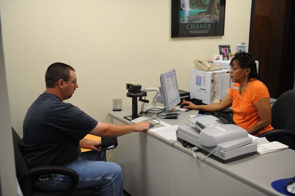 SHAW AIR FORCE BASE, S.C. -- Jonathan Swiney, Inactive Ready Reserve member, places a finger on  a finger print reader while Edna Talley, 20th Force Support Squadron customer service rep, records information for a military ID card during the IRR Muster July 19. An IRR Muster is a medical screening for all former active duty members now on IRR status and also provides them with a chance to talk with an Air Force Reserve recruiter and get a military ID card if necessary. (U.S. Air Force Photo/Staff Sgt. Henry Hoegen)