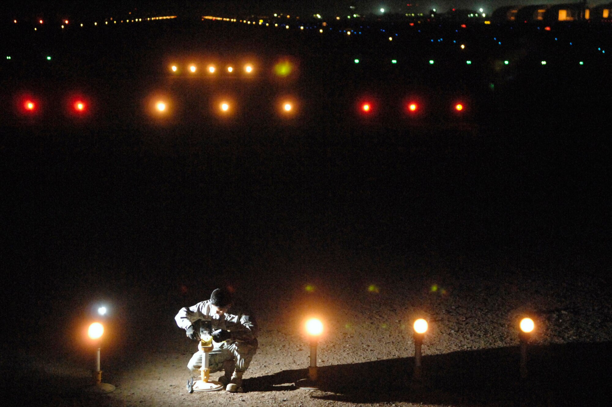 Staff Sgt. Samnang Lay replaces a bulb on an approach light July 5 at Joint Base Balad, Iraq. Sergeant Lay is a 332nd Expeditionary Civil Engineer Squadron electrician deployed from Ellsworth Air Force Base, S.D. (U.S. Air Force photo/Senior Airman Julianne Showalter) 
