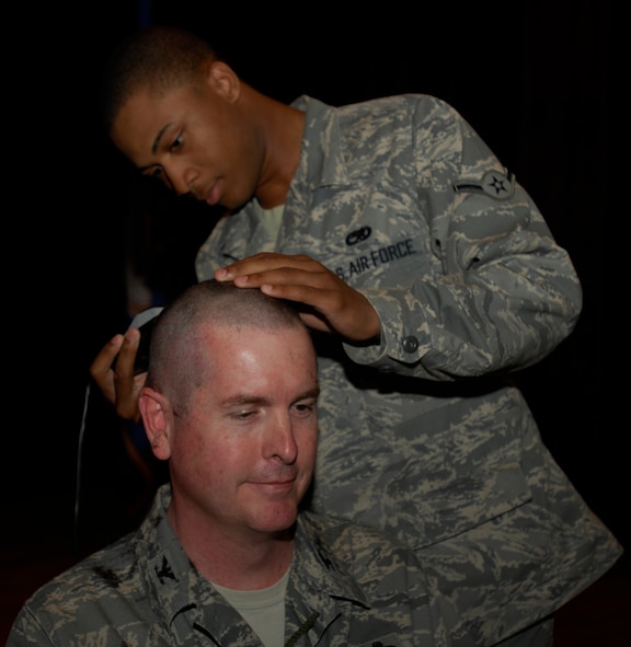 MINOT AIR FORCE BASE, N.D. -- Airman 1st Class Kennard Green, 5th Munitions Squadron weapons specialist, gives Col. Donald Kirkland, 5th Maintenance Group commander, a close shave as part of a recent fundraising effort for Airman Against Drunk Driving here. The 5th MXG raised a total of $1,091 for AADD by letting the two squadrons that donated the most money shave the heads of the 5th MXG commander and superintendent at their commander's call. (Courtesy photo)