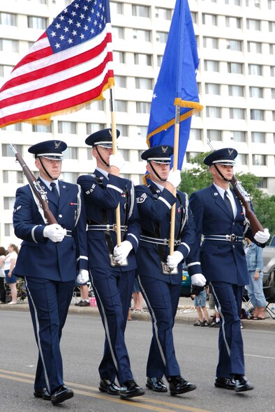MINOT, N.D. – Airman 1st Class Ryan Stahl, Airman 1st Class Christopher Slade, Staff Sgt. Kyle Meyer and Airman 1st Class Ryan Morgan, all members of the Minot Air Force Base Honor Guard, show respect for our Nation’s colors during the North Dakota State Fair Parade here July 20. Both the 5th Bomb Wing and 91st Missile Wing were well represented during the parade. (U.S. Air Force photo by Staff Sgt. Thomas Dow)