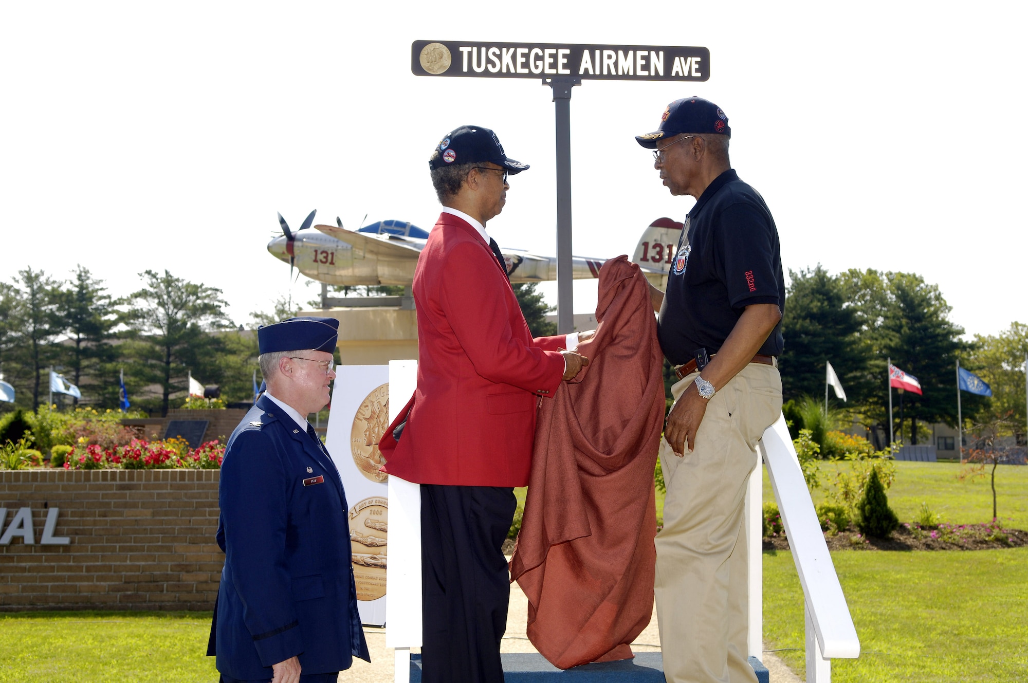 Retired Lt. Gen. Russell Davis (left), national president of Tuskegee Airmen, Incorporated, and retired Master Sgt. Shade Lee, a documented original Tuskegee Airman, unveil a new street sign featuring an image of the Congressional Gold Medal at the rededication of Tuskegee Avenue July 17 at McGuire Air Force Base, N.J. The ceremony, which was part of the 37th Tuskegee Airmen National Convention ending July 20 in Philadelphia, was held in honor of the Tuskegee Airmen's significant accomplishments, which include the Congressional Gold Medal awarded in March 2007. (U.S. Air Force photo/Kenn Mann) 