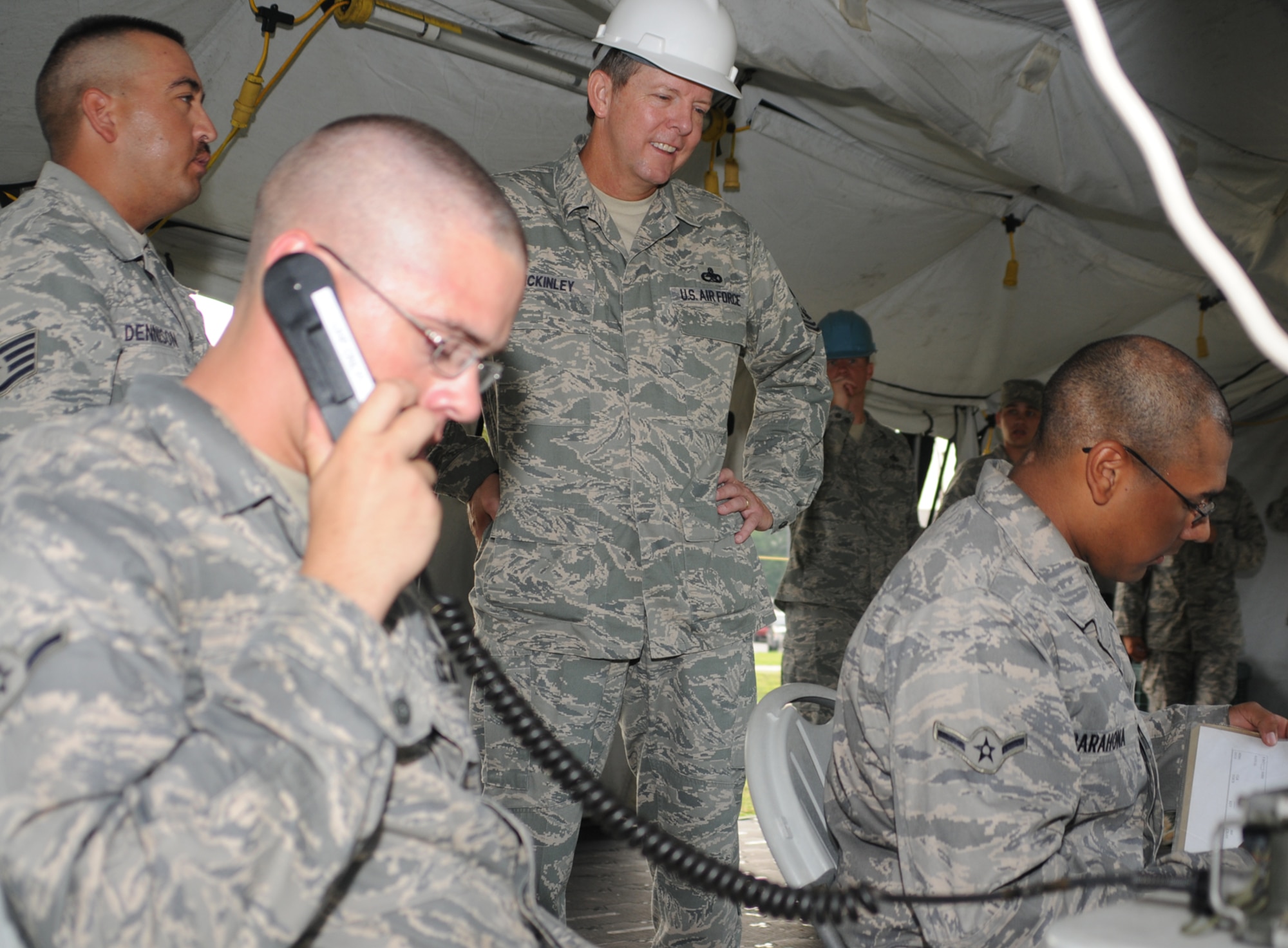 Staff Sgt. Glenn Dennison, standing left, an instructor in the 338th Training Squadron, and Chief McKinley observe Airmen Joshua Nauman, left, and Lester Barahona during a tour of the squadron’s air expeditionary force training area.  (U.S. Air Force photo by Kemberly Groue)
