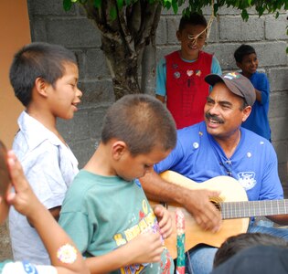 LA PAZ, Honduras - A member from the IAAFA NCO course sings "La Cucaracha" to the children of the San Antonio Orphanage July 19. More than 40 volunteers from JTF-Bravo, 1-228th Aviation Regiment and the Inter-American Air Force Academy NCO course came to the orphanage to play games, have a cookout and spend time with the children.