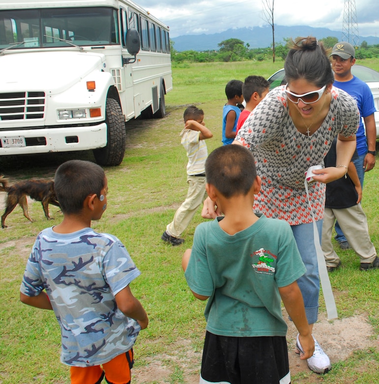 LA PAZ, Honduras ? Army Capt. Heidi Beekman, 1-228th Aviation Regiment, gives out stickers to children at the San Antonio Orphanage July 19.  More than 40 volunteers from JTF-Bravo, 1-228th, the Inter-American Air Force Academy NCO Course came to the orphanage to play games, have a cookout and spend time with children.