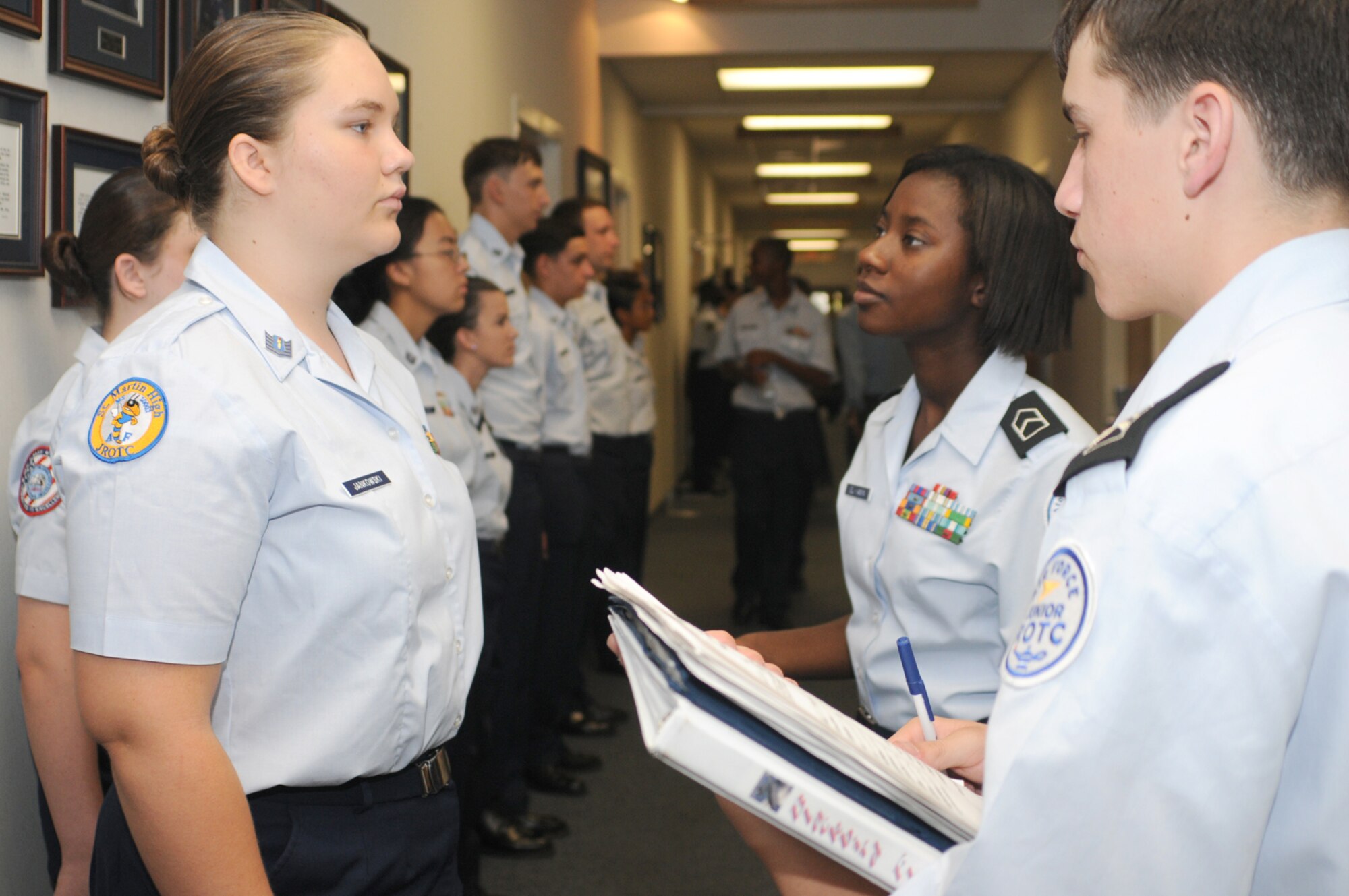 Cadet Staff Sgt. Katelyn Jankowski, left, has her uniform inspected by Cadet 2nd Lt. Karimah El-Amin and Cadet Lt. Col. Kyle Chevis of Blackbird Flight, July 16 during the Junior ROTC Summer Leadership School at the Keesler NCO Academy.  Cadet Jankowski, 15, is from St. Martin High School, Miss.  Cadet El-Amin, 16, is from Fontainbleau High School and Cadet Chevis, 17, is from St. Paul High School, both in Louisiana.  The students represent 21 high schools in Mississippi, Louisiana, Alabama, Arkansas and Florida.  Biloxi High School is the program manager for the annual weeklong event.  (U.S. Air Force photo by Kemberly Groue)