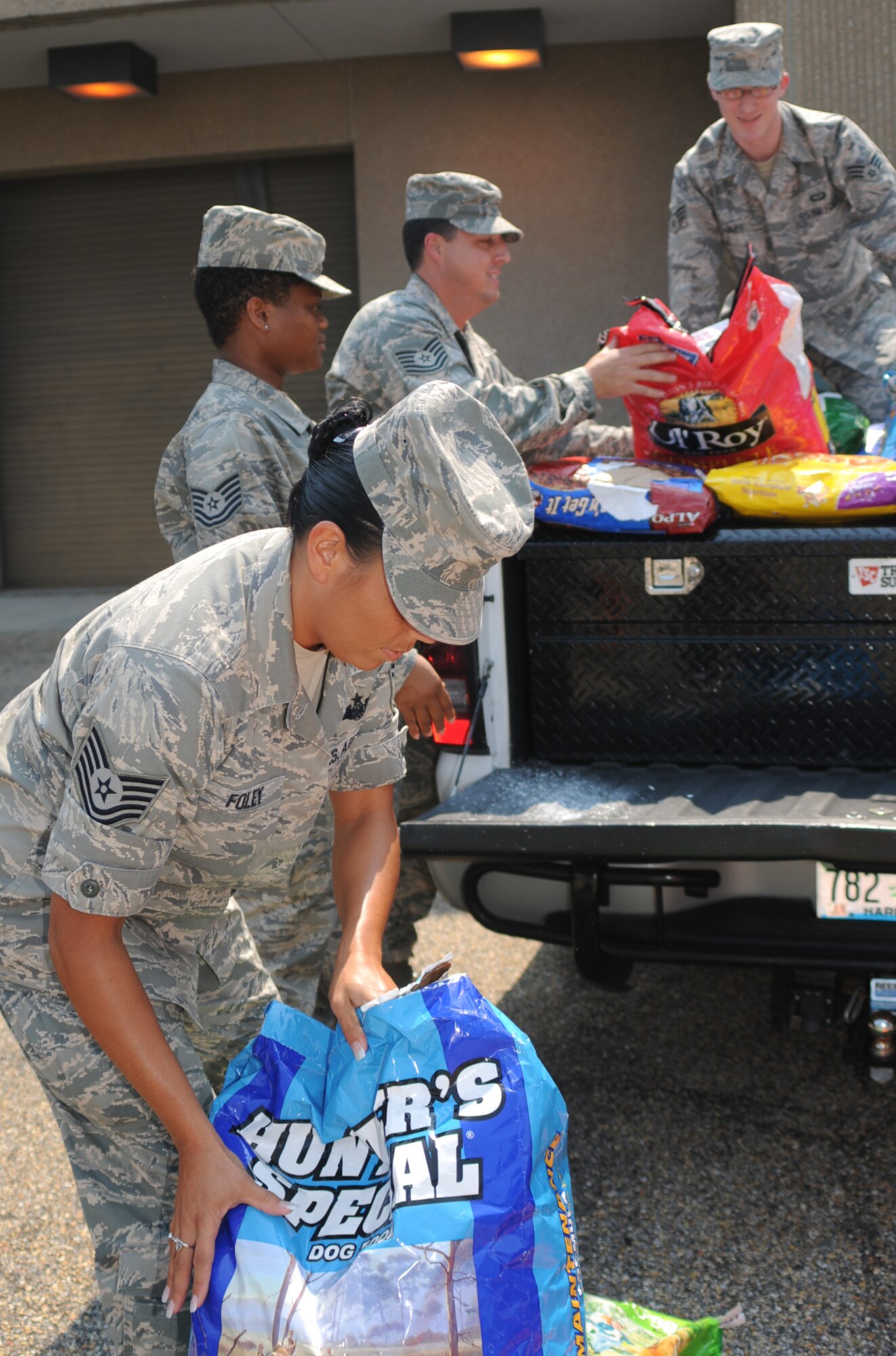 From left, Tech. Sgts. Judy Foley, LaKeitha Luster and Richard Lopez, and Senior Airman Eric Huff, load dog food onto a truck for delivery to the Humane Society of South Mississippi, Friday.  Sergeant Foley and Airman Huff are students and Sergeants Luster and Lopez are instructors in the 335th Training Squadron.  Tech. Sgt. Asha Gray, one of the squadron’s instructors, spearheaded the three-week drive that began June 23 and collected 6,000 pounds of pet food for the animal shelter.  (U.S. Air Force photo by Kemberly Groue)
