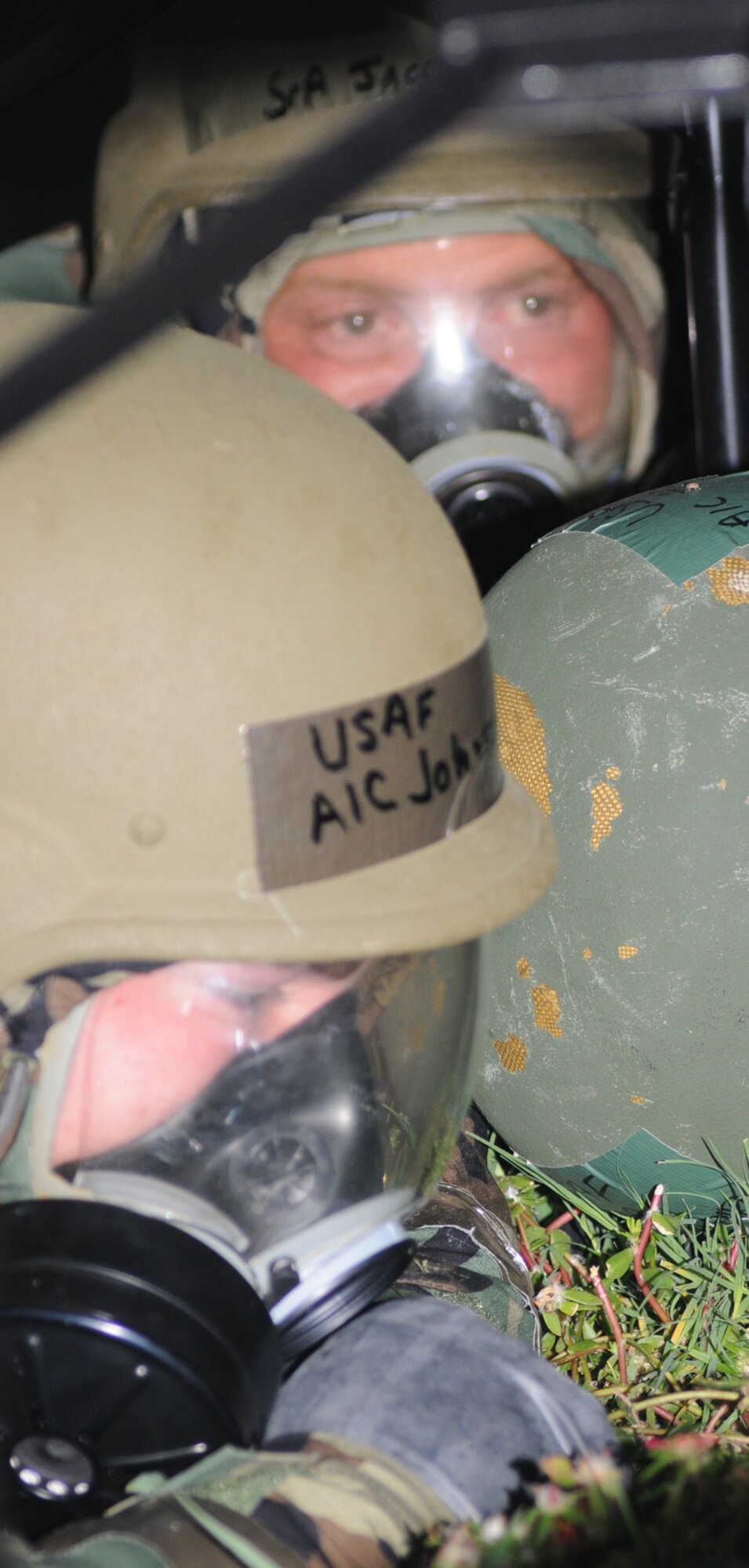 Airman 1st Class Ian Johnson, left, and Senior Airman Jacob Williams take cover under a table during a field exercise July 16.  They’re assigned to the 81st Force Support Squadron.  (U.S. Air Force photo by Kemberly Groue)