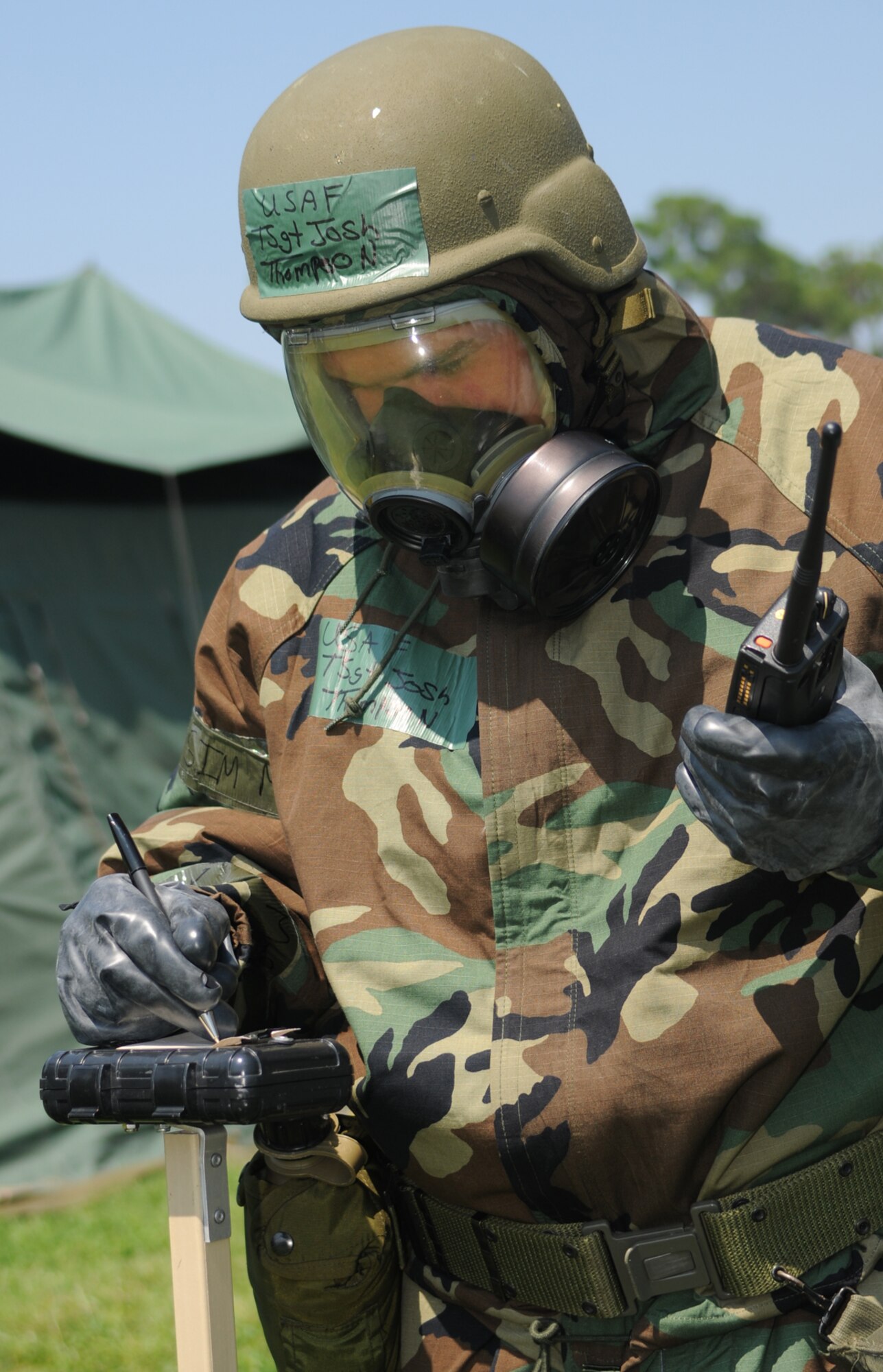 At left, Tech. Sgt. Joshua Thompson, 81st Supply-Transportation Squadron, uses M-8 paper to check for chemical agents during the July 16 field exercise.  (U.S. Air Force photo by Kemberly Groue)