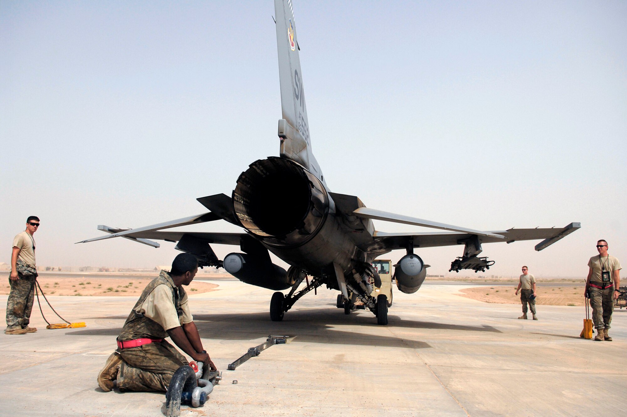 Members of the 77th Aircraft Maintenance Unit position an F-16 Fighting Falcon for an engine run up July 16 at Joint Base Balad, Iraq. The links and bar attached to the arresting hook secures the aircraft to the ground to prevent any movement and ensure the safety of the Airmen on the ground. The run up of the engine to full afterburner allows the engine mechanics and crew chiefs to ensure all systems are fully functional before putting the fighter back into operational use. The aircraft and members of the 77th AMU are deployed from Shaw Air Force Base, S.C. (U.S. Air Force photo/Senior Airman Julianne Showalter) 
