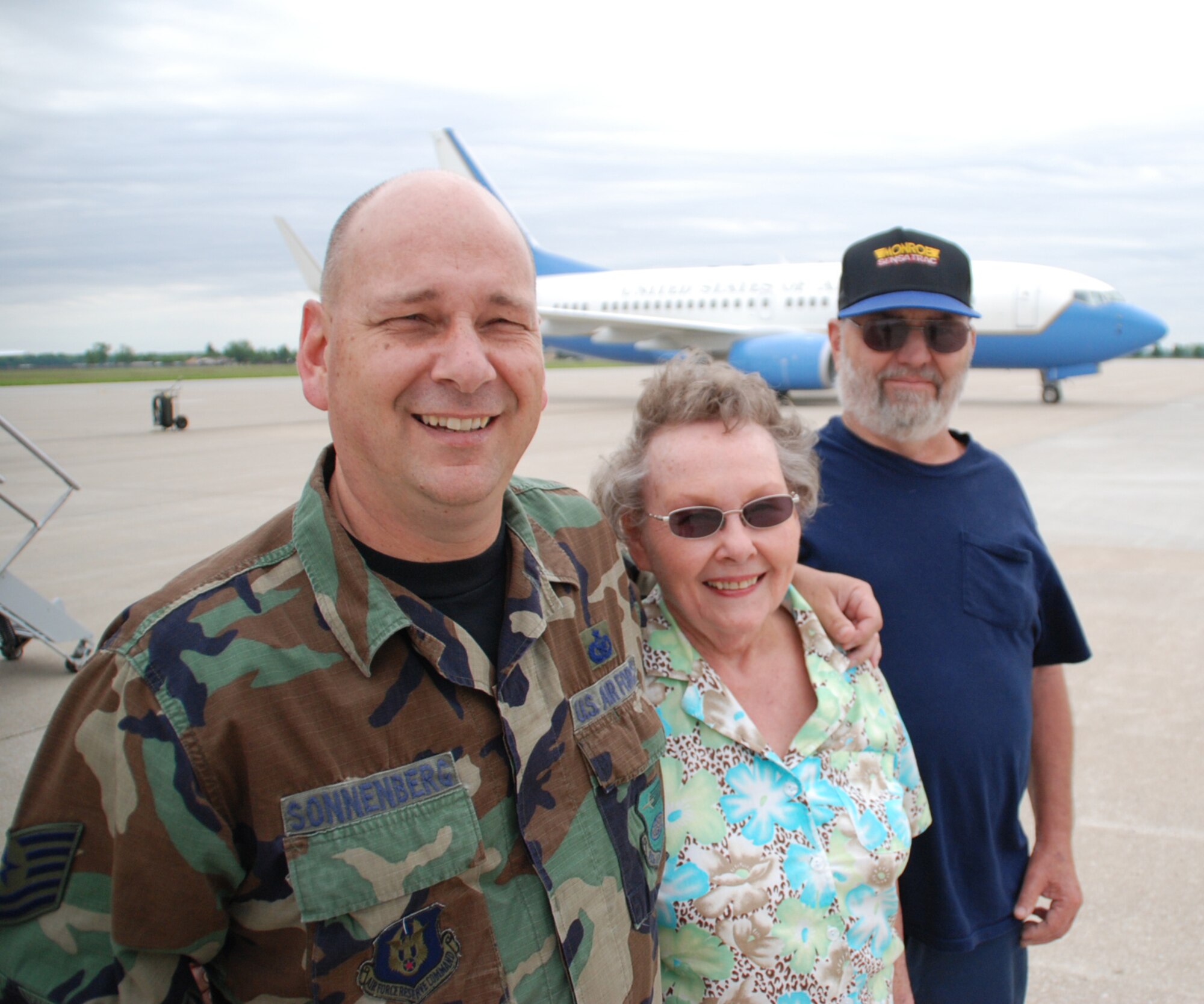 Smiles and patriotism were evident for the Sonnenbergs.  932nd Airlift Wing headquarters staff member Tech Sgt. Gerald Sonnenberg stands with his proud parents a few moments after reenlisting for another six years with the Air Force Reserve Command unit located at Scott Air Force Base, Ill.  Behind them is the newest aircraft from 2007, the C-40C plane.  Photo/Maj. Stan Paregien