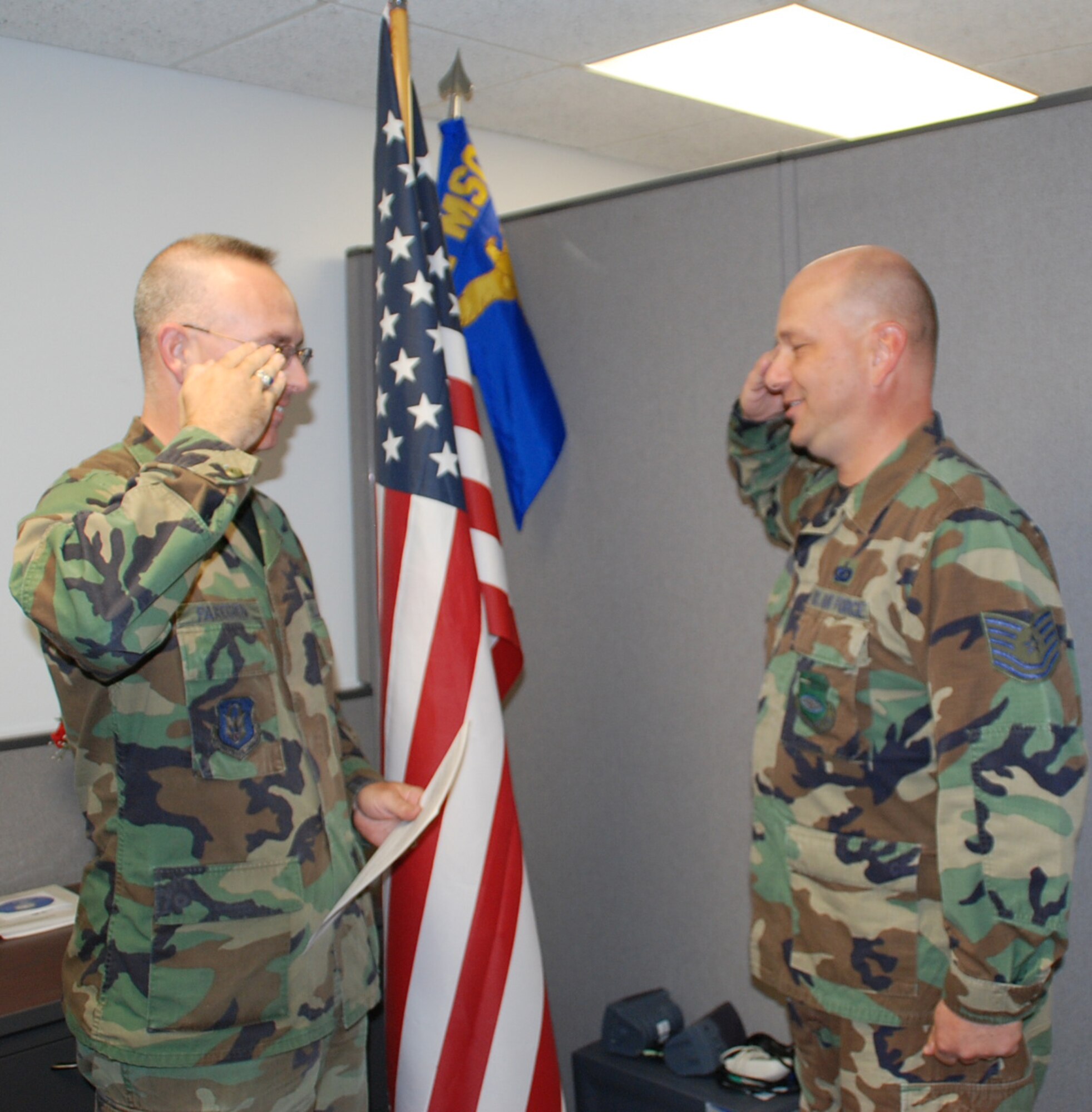 Citing his enjoyment of serving his country and his unit, Tech. Sgt. Gerald Sonnenberg (right) salutes as he completes his reenlistment process at the 932nd Airlift Wing.  U.S. Air Force photo/Maj. Stan Paregien