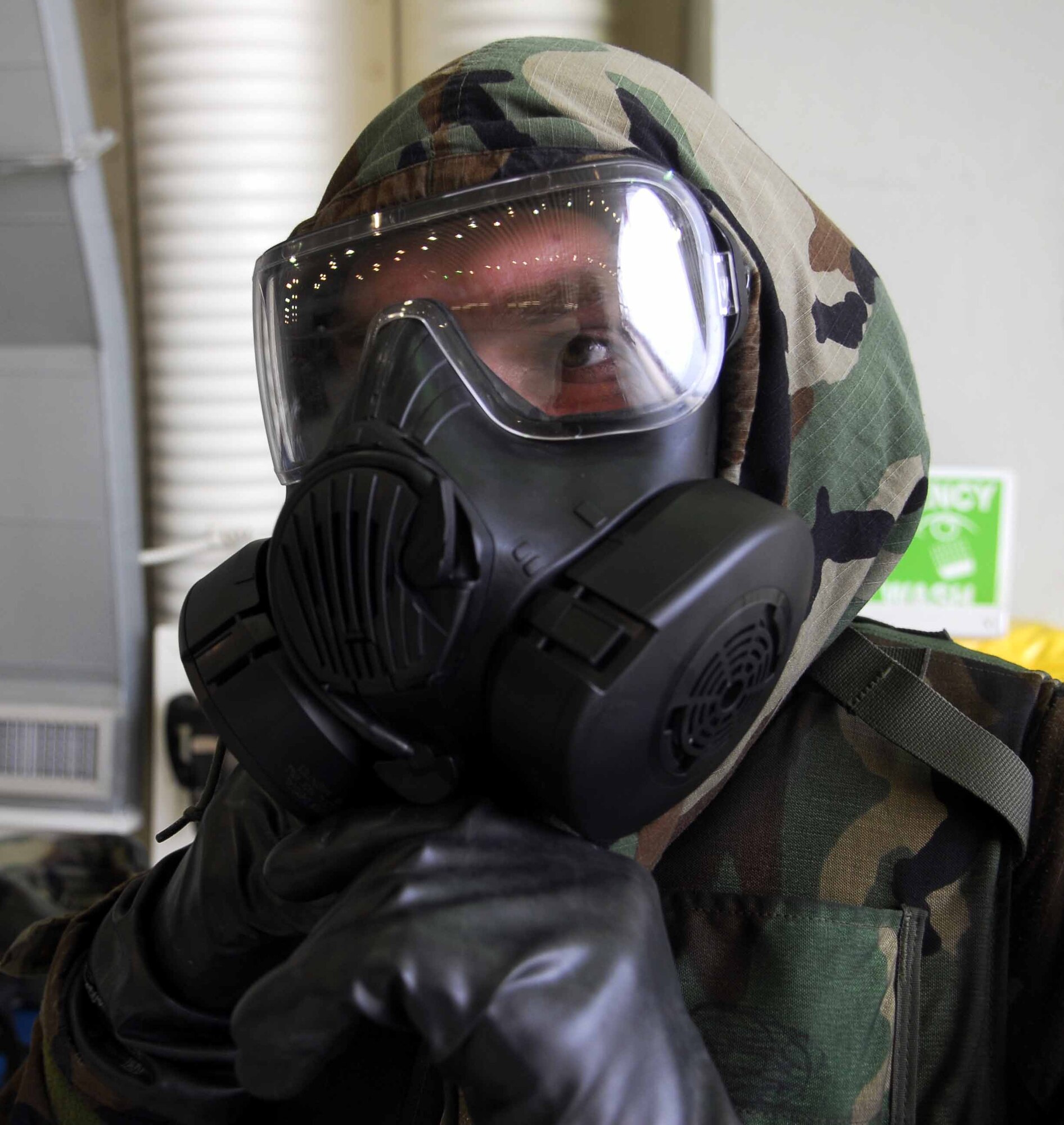 OSAN AIR BASE, Republic of Korea – Airman 1st Class Jeffery Douglas attaches his hood to his M-50 protective mask during an exercise here July 22. The week-long exercise tests Team Osan’s readiness and ability to execute combat operations, receive follow-on forces and defend the base from attack. Airman Douglas is a crew chief assigned to the 51st Aircraft Maintenance Squadron. (U.S. Air Force photo by Senior Airman Christopher Boitz)