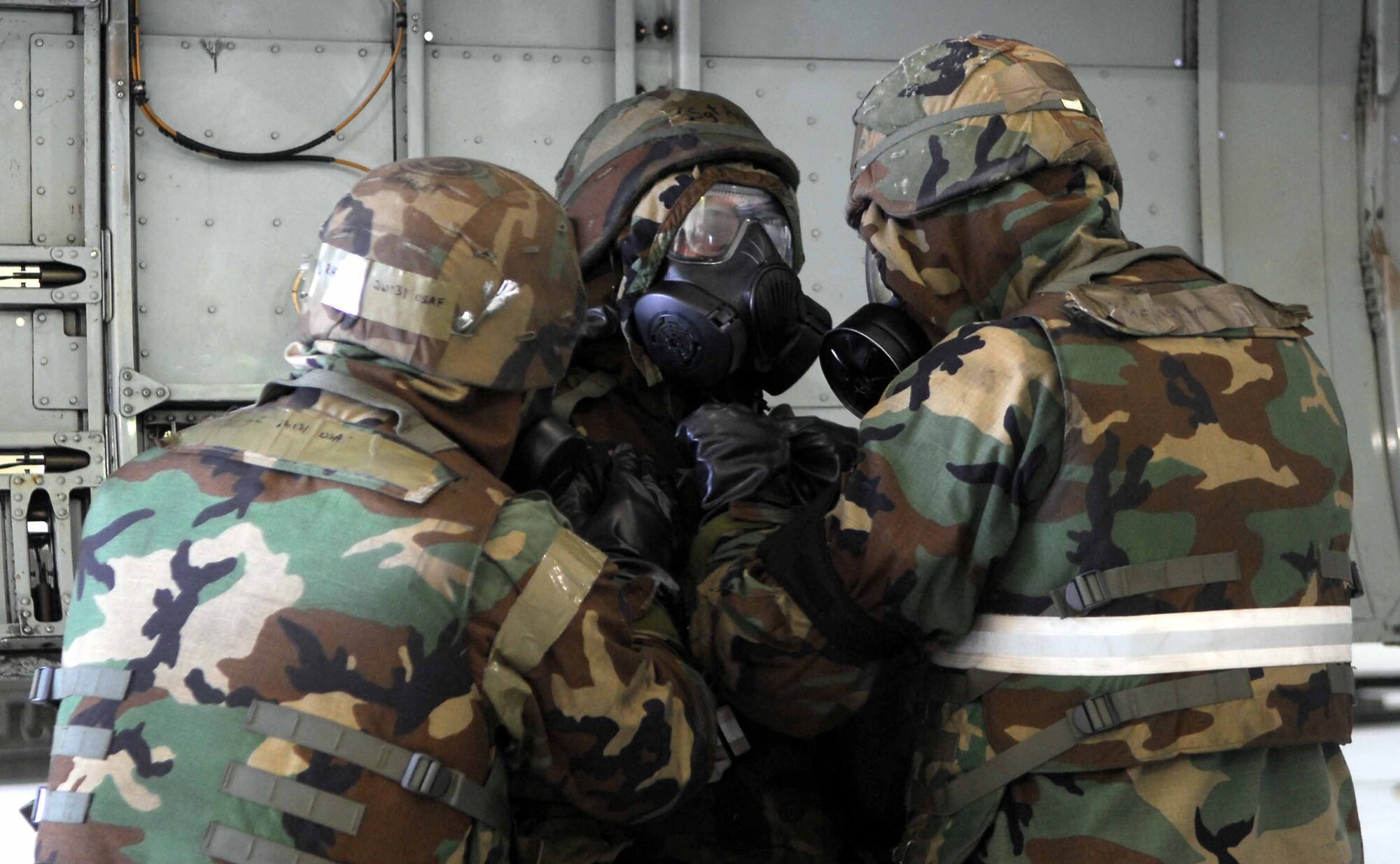 OSAN AIR BASE, Republic of Korea -- Airman 1st Class Chris Ray, (left)  and Staff Sgt. Rueben Amaya, (right) conduct a buddy check on Staff Sgt. Shawn Syman during a base-wide exercise here July 22. All three Airmen are aircraft armament systems specialists assigned to the 51st Aircraft Maintenance Squadron. (U.S. Air Force photo/Senior Airman Christopher Boitz)