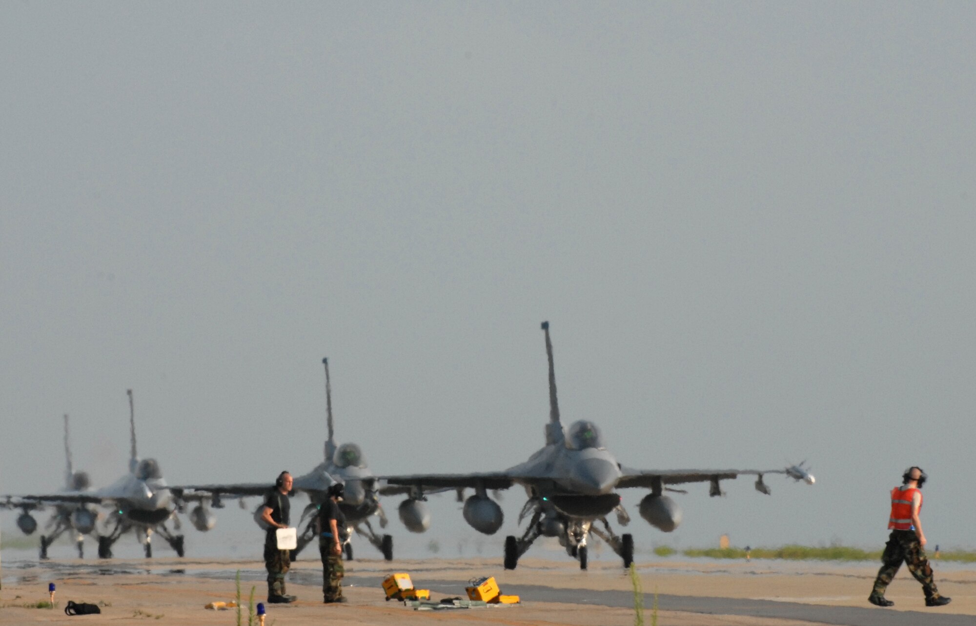 KUNSAN AIR BASE, Republic of Korea -- Members of the 8th Fighter Wing End-of-Runway team prepare to launch F-16 jets during the peninsula wide operational readiness exercise here July 22.  Kunsan is participating in the PENORE to evaluate its readiness and ability to perform its wartime mission.  (U.S. Air Force photo/TSgt Quinton T. Burris)
