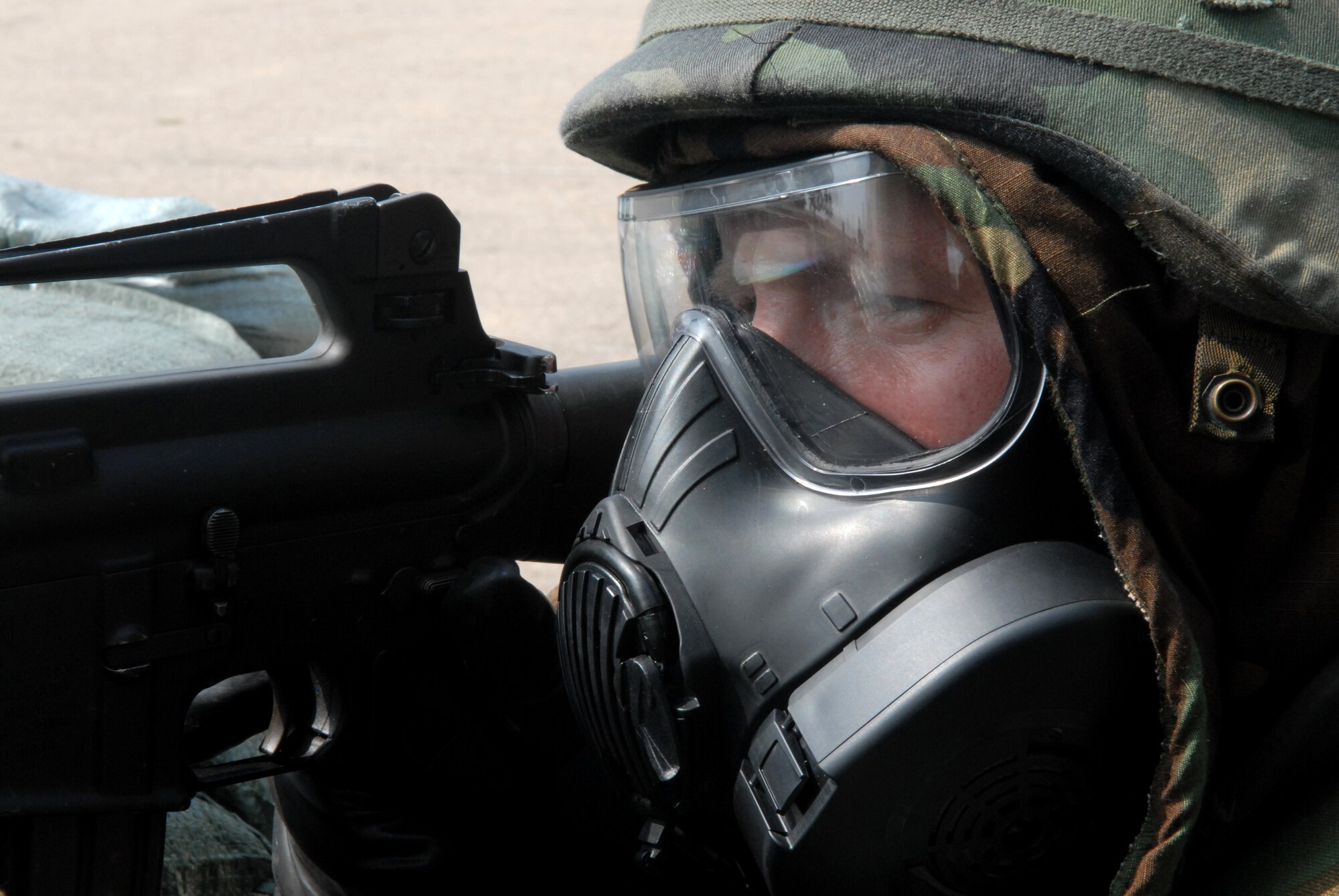 Senior Airman Ian Cox-Train, 8th Security Forces augmentee , defends  an entry control point with a  M16 rifle, wearing Mission Oriented Protective posture level 4 (MOPP) gear during the BEVERLY BULLDOG 08-03 peninsula  wide operational readiness exercise here July 22. The PENORE is a training exercise among United States Forces in Korea, keeping Wolf Pack Airmen ready to execute the mission. (U.S. Air Force photo by: Senior Airman Angela Ruiz)