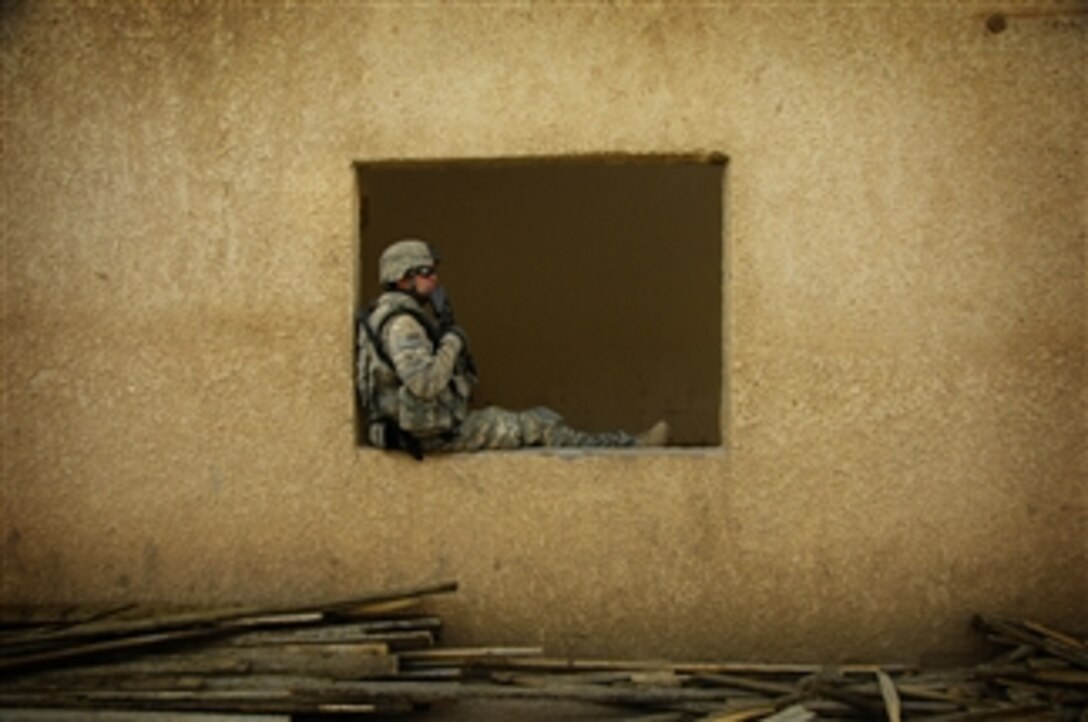 U.S. Army Spc. Eric Waddle, of 1st Battalion, 27th Infantry Regiment, 25th Infantry Division, takes a break as he provides security for and observes Iraqi workers renovating a school in the Al Awad region of Iraq on July 17, 2008.  