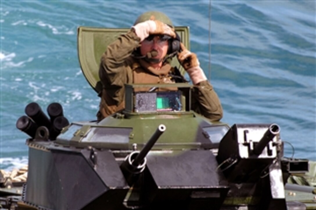 A U.S. Marine peers out of his amphibious assault vehicle as he prepares to embark the amphibious dock landing ship USS Carter Hall during a composite unit training exercise in the Atlantic Ocean, July 19, 2008. The Marine is assigned to the 26th Marine Expeditionary Unit.