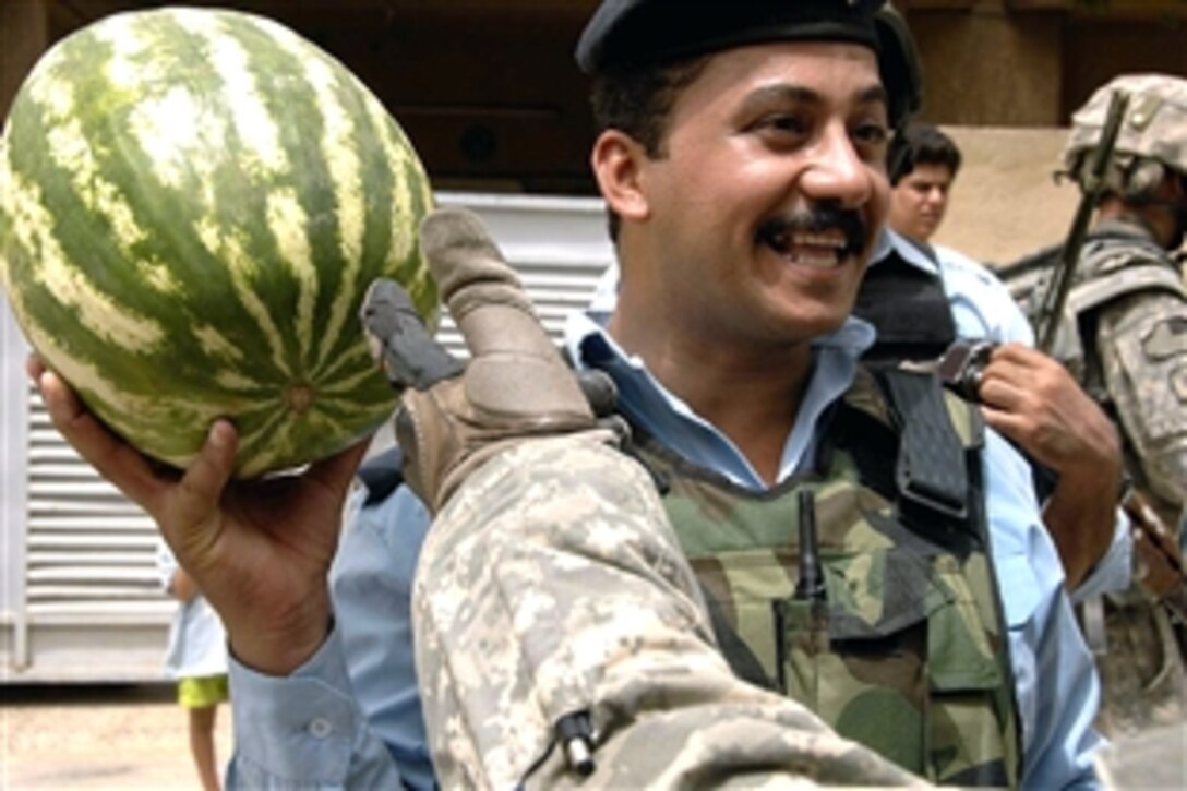 An Iraqi policeman shows off the watermelon he has just bought from a street vendor during a patrol with U.S. soldiers in the Ghazaliya district of Baghdad, Iraq, July, 17, 2008. The soldiers are assigned to the 101st Airborne Division's,1st Squadron, 75th Cavalry. 
