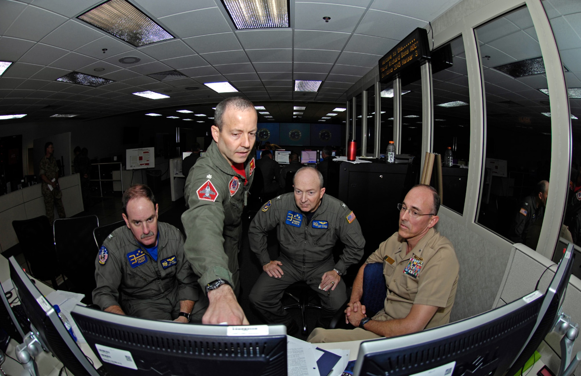 Capt. Paul Innis, Cmdr. David Little, Capt. Chris Sprinkle, and Cmdr. Doug Anderson discuss a battle strategy in the 613th Air and Space Operations Center at Hickam Air Force Base, Hawaii on July 22.  The officers are providing command and control for the airpower in Exercise Rim of the Pacific 2008. (US Air Force photo / Master Sgt. Chris Vadnais)

