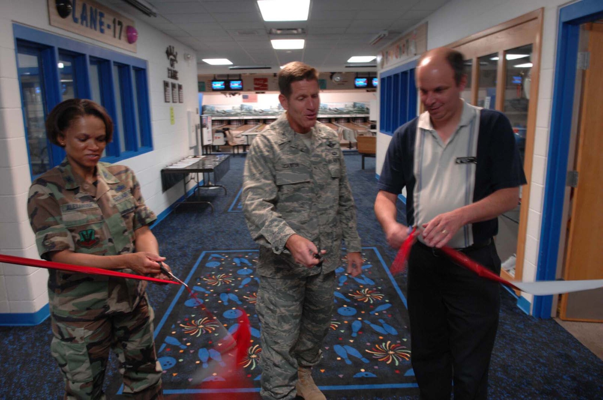 (Left) Col. Renita D. Alexander, 28th Mission Support Group commander, Col. Peter Castor, 28th Bomb Wing vice commander, and Kenneth Young, Bandit Lanes manager, cut the ribbon for the re-opening of the Bandit Lanes bowling alley here July 23.  Along with these renovations, there will be one dollar bowling July 24 to July 26; there will also be dollar bowling every Thursday night. (U.S. Air Force photo/Airman 1st Class Adam Grant) 

