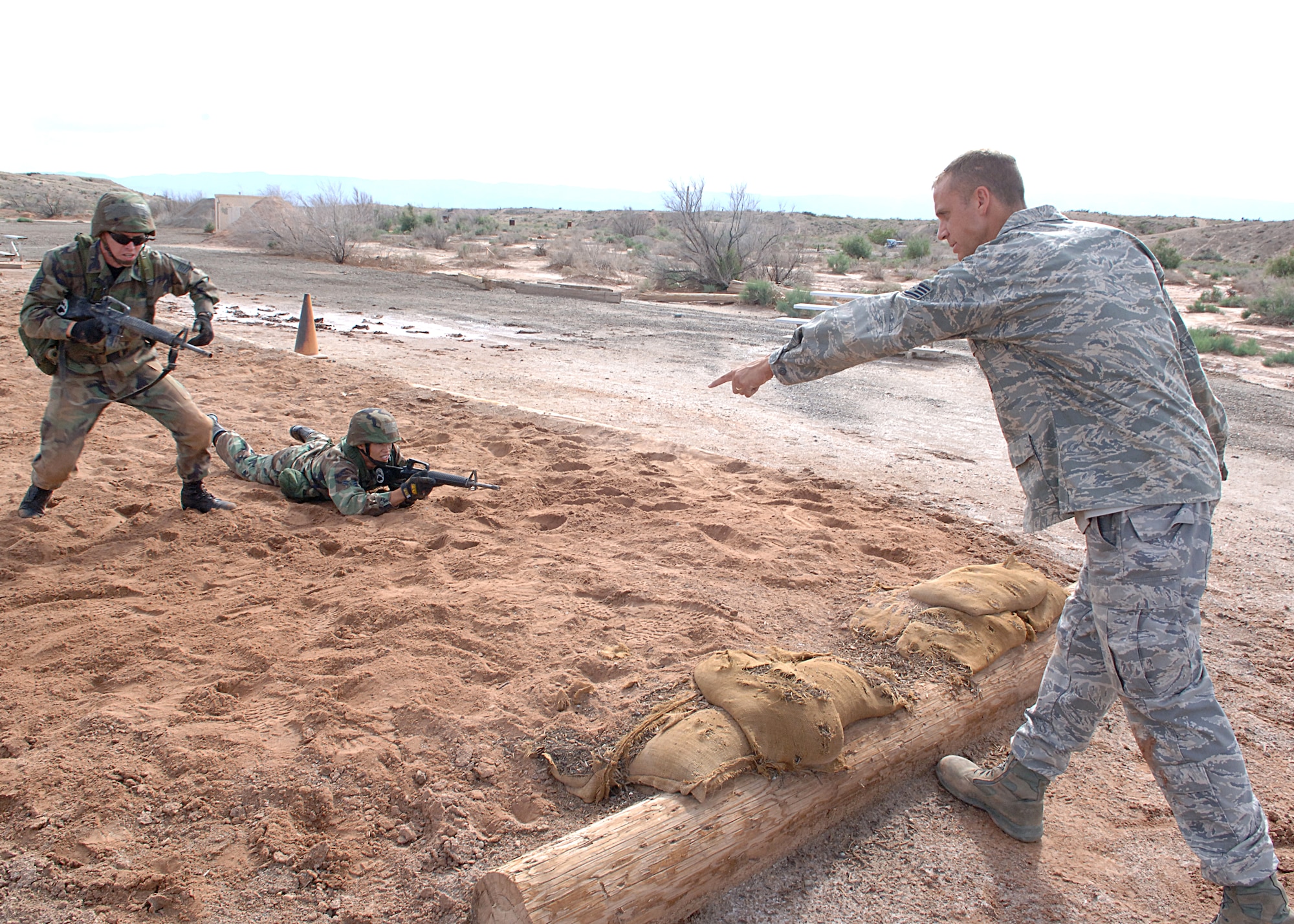 Staff Sgt. Jason Broadaway, 49th Security Forces Squadron, directs Master Sgt. Michal Wells, 49th Materiel Maintenance Squadron, to move during an exercise at the Combat Skills Training Course at Holloman Air Force Base, N.M., July 22.  The Combat Skills Training Course is a 19 hour course that consists of pre-deployment training and combat tactical skills training.  (U.S. Air Force photo/Airman 1st Class John Strong)  
