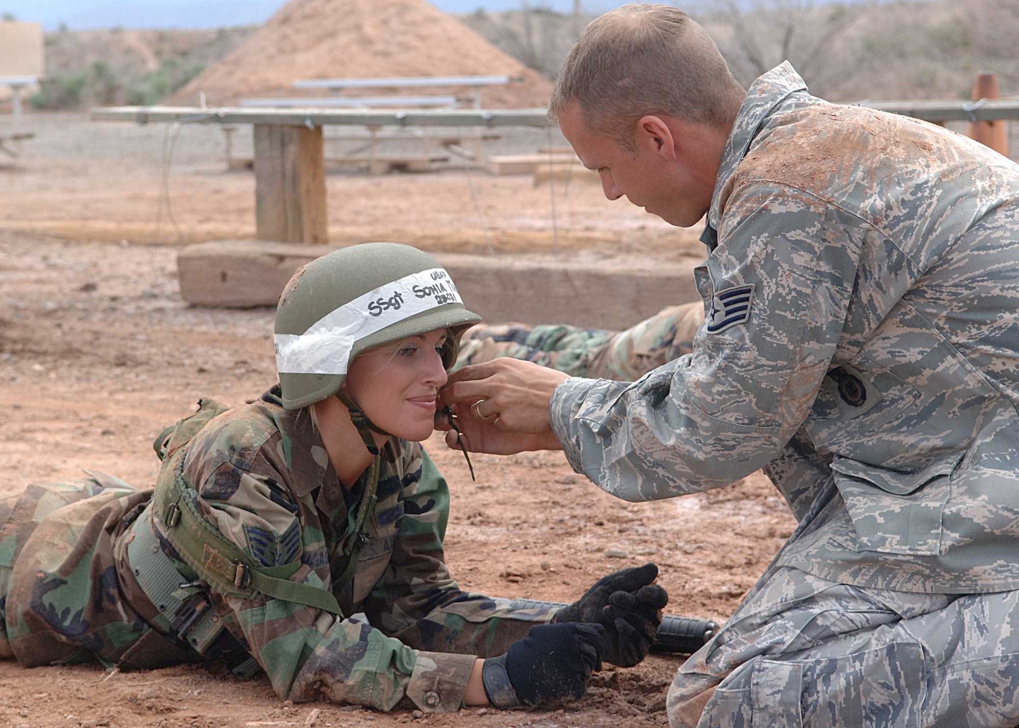 Staff Sgt. Jason Broadaway, 49th Security Forces Squadron, adjust the helmet of Staff Sgt. Sonia Magagnin, 49th Materiel Maintenance Support Squadron before an exercise at the Combat Skills Training Course at Holloman Air Force Base, N.M., July 22.  The Combat Skills Training Course is a 19 hour course that consists of pre-deployment training and combat tactical skills training.  (U.S. Air Force photo/Airman 1st Class John Strong)  
