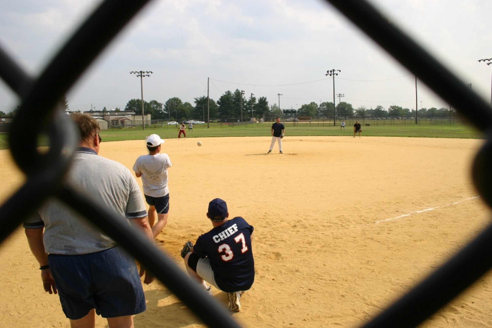 Colonel Glenn Yap, 305th Medical Group commander, hits a ball to center field during the Chief's vs. Eagles softball game on 22 July. The game was close thoughout, but the chief's were able to hang on to a one point lead, winning the game 14-13.
