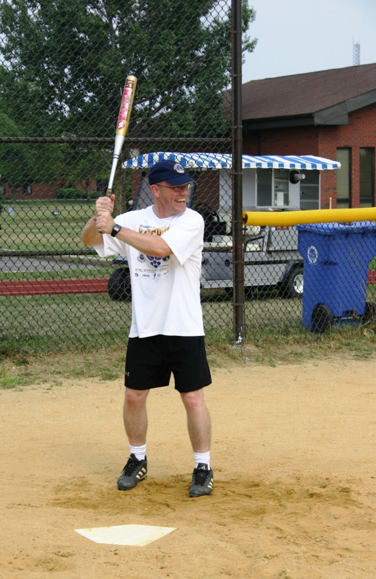 Chief Master Sgt. Warren Wofford, 305th Mission Support Group, smiles while up to bat during the Chief's vs. Eagles softball game on 22 July. The game was close thoughout, but the chief's were able to hang on to a one point lead, winning the game 14-13.
