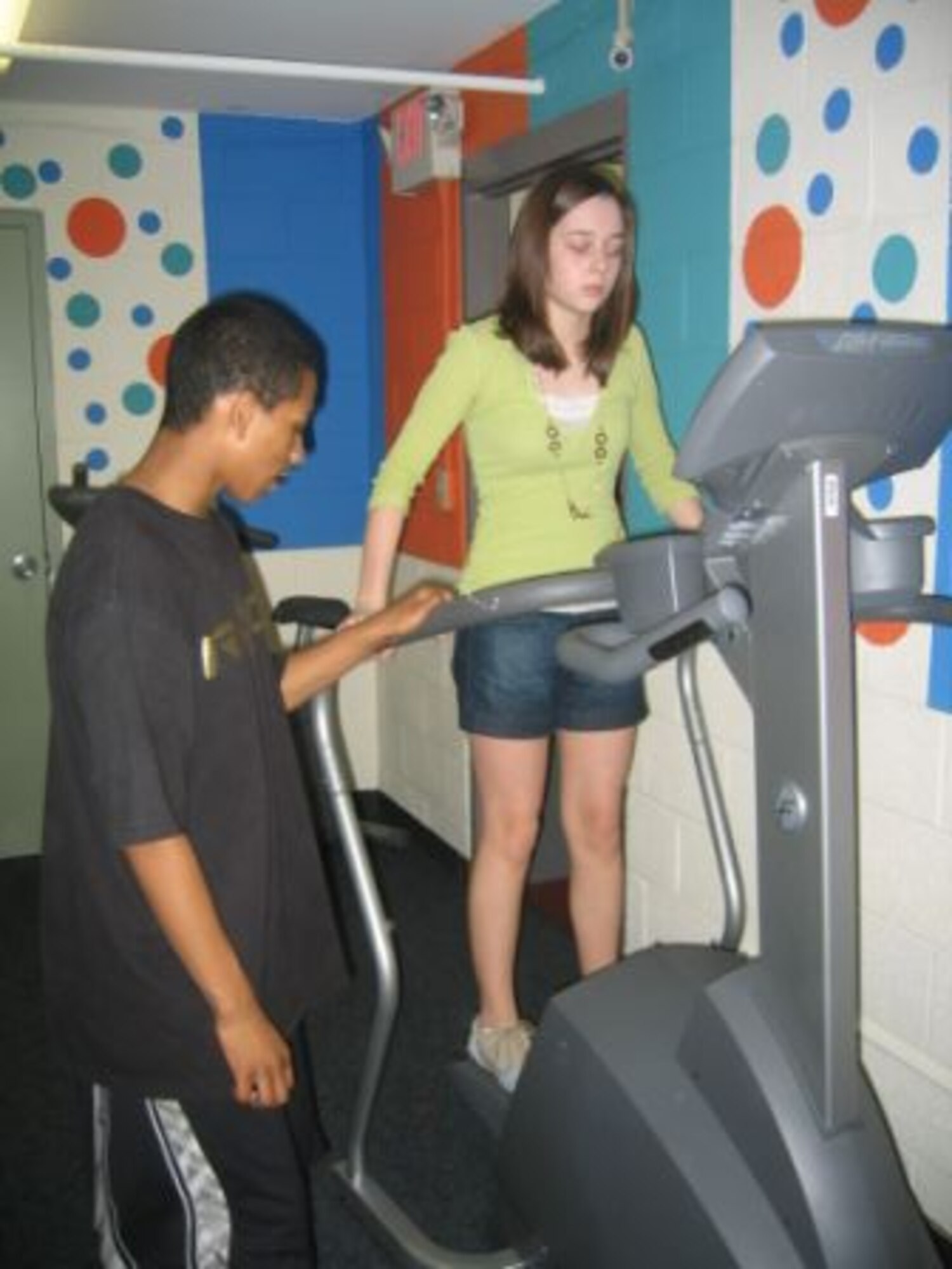 Donte Jenkins (left) waits his turn as Lauren Moore (right) uses a Stairmaster machine in the recently constructed fitness center at the Teen Center on Vance Air Forec Base, Okla. The project was finished at the end of April as part of an Eagle Scout project. (photo by Kate Holdeman)