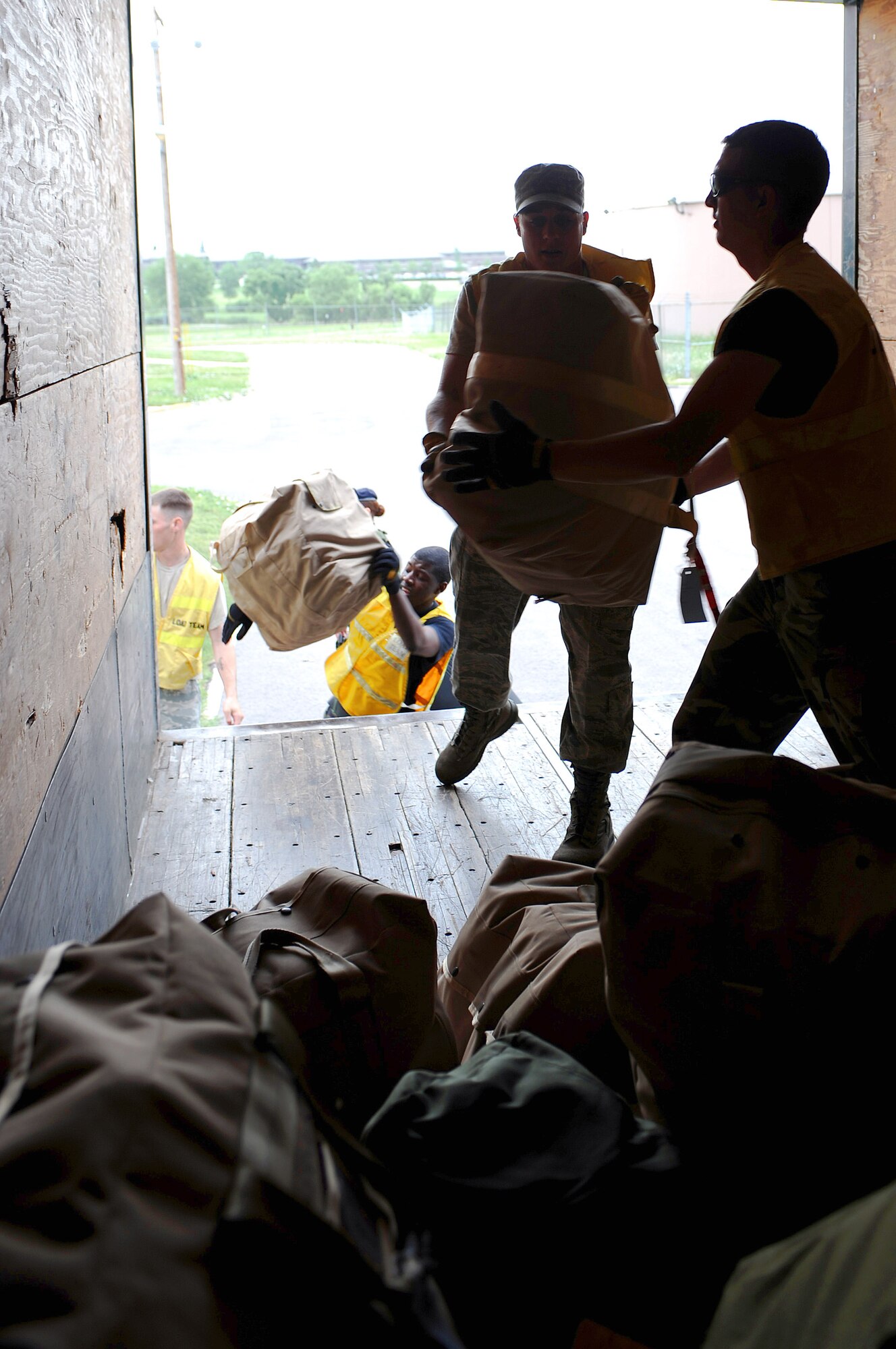 Staff Sgt. Jerry Simmons (right) takes a mobility bag from Senior Airman Christopher Bohach while loading personal and mobility bags of deploying personnel July 22 at Ellsworth Air Force Base, S.D. More than 200 Ellsworth AFB Airmen deployed in support of operations Iraqi Freedom and Enduring Freedom. Sergeant Simmons is a 28th Civil Engineer Squadron electrical systems craftsman, and Airman Bohach is a 28th CES heating, ventilation, refrigeration and air conditioning journeyman. (U.S. Air Force photo/Senior Airman Marc I. Lane) 