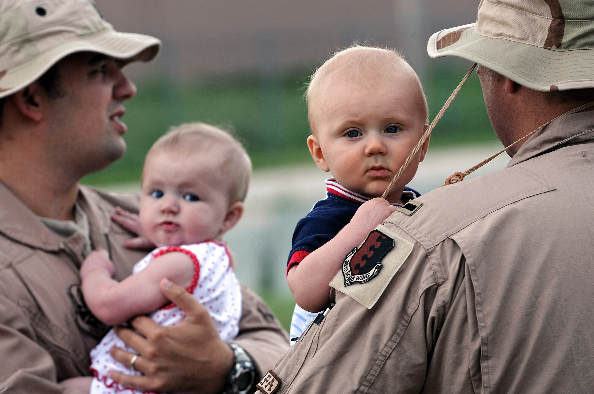 Capt. Steven Fowler (left) and 1st. Lt Daniel Silk hold their children before deploying July 22 at Ellsworth Air Force Base, S.D. Captain Fowler, a 34th Bomb Squadron weapons system operator, and Lieutenant Silk, a 34th Bomb Squadron B-1B Lancer pilot, will be deployed to Southwest Asia in support operations Iraqi Freedom and Enduring Freedom. (U.S. Air Force photo/Senior Airman Marc I. Lane) 
