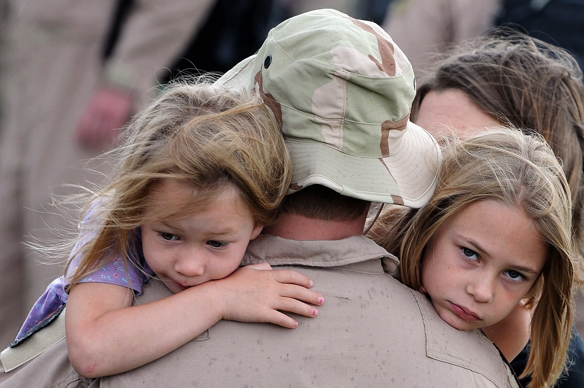 1st. Lt. William Jacks hugs his daughters Rachel (left) and Anna July 22 at Ellsworth Air Force Base, S.D. Lieutenant Jacks, a 34th Bomb Squadron B-1B Lancer pilot, will be deployed to Southwest Asia in support of military operations being conducted in various locations worldwide. (U.S. Air Force photo/Senior Airman Marc I. Lane) 