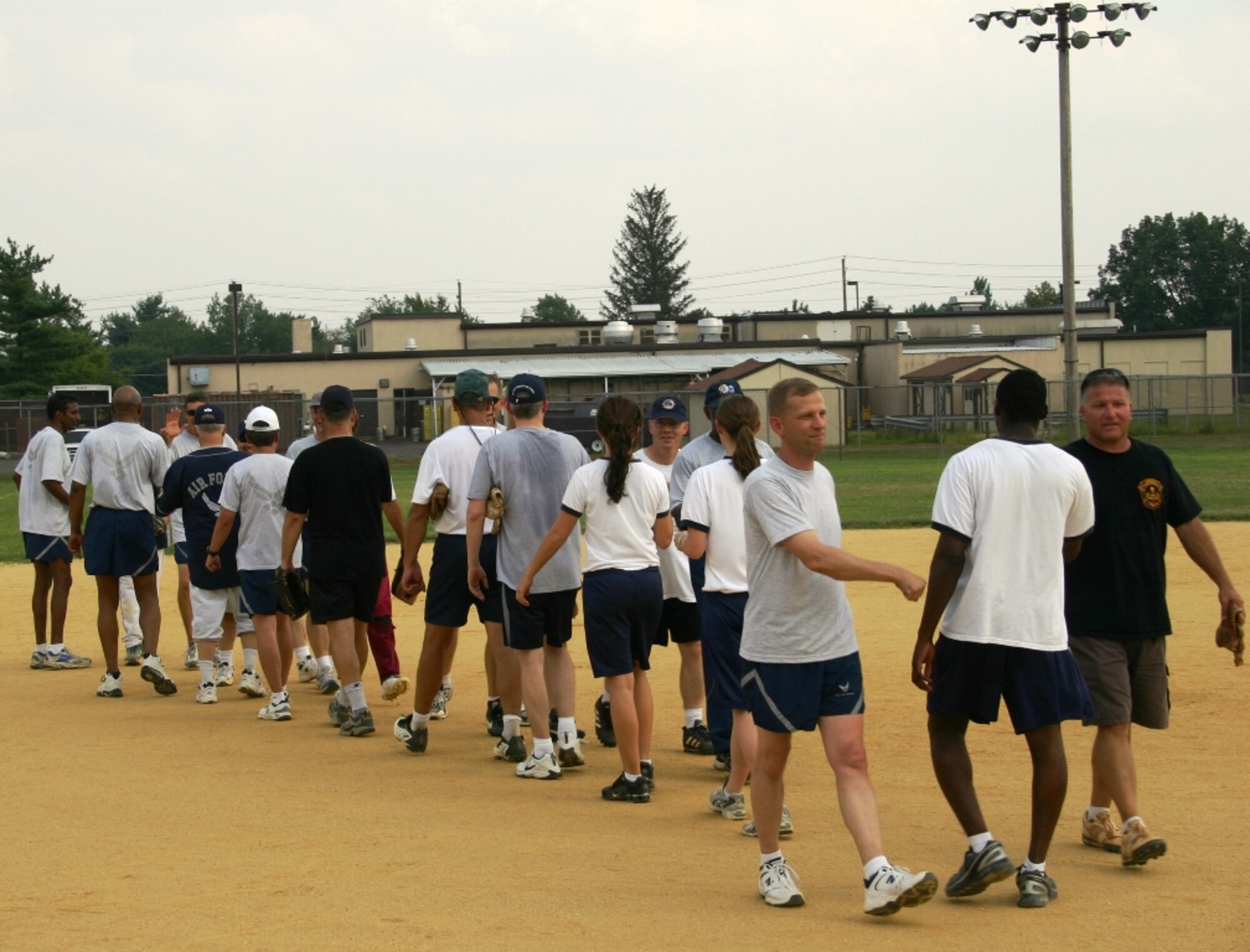 Team McGuire Chiefs and Eagles shake hands after an hard fought softball game where the chiefs came away with base bragging rights with a score of 14-13.