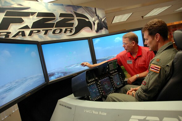 HICKAM AIR FORCE BASE, Hawaii -- Mark Dougherty, from Lockheed Martin Aeronautics Company demonstrates the F-22 Raptor flight simulator to Major James "Saw" Sage, a F-15 pilot with the 199th Fighter Squadron, Hawaii Air National Guard here July 22. The F-22 Raptor is the Air Force's newest fighter aircraft. Its combination of stealth, supercruise, maneuverability, and integrated avionics, coupled with improved supportability, represents an exponential leap in warfighting capabilities. (U.S. Air Force photo/ Master Sgt. Kristen Stanley) 
