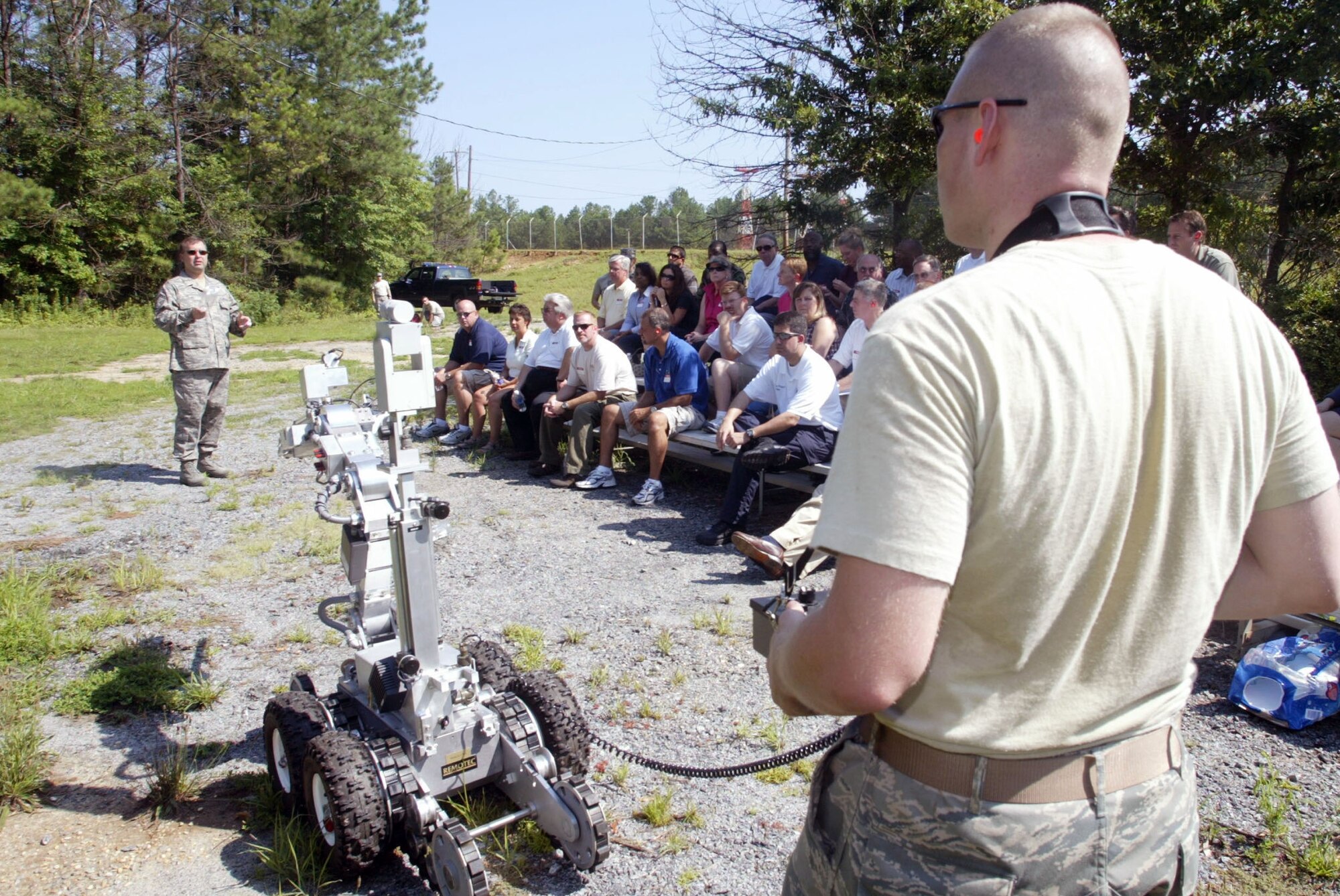 Senior Airman Justin Krautkremer from the explosive ordinance disposal section of the 94th Civil Engineering Squadron demonstrates some of the abilities of the F6A Hazardous Duty Unmanned vehicle robot while Senior Master Sgt. William (Glen) Clare, section superintendent, briefs visiting employers on the robot's capability to detonate and detect ordnance. The touring group of employers were visiting Dobbins Air Reserve Base July 12, 2008 in recognition of Employers Day.