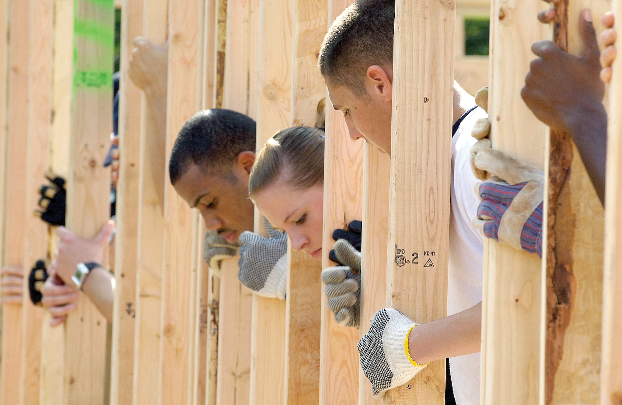 Team Tinker takes on a different meaning as the Habitat for Humanity volunteers from Tinker line up a newly-lifted exterior wall frame while others secure it.  From left are Airman 1st Class Aaron Barnes, 960th Airborne Air Control Squadron; Amn. Ashley Dommer, 32nd Combat Communications Squadron; and Airman 1st Class Zach Westover, 960th AACS.(Air Force photo/Margo Wright)