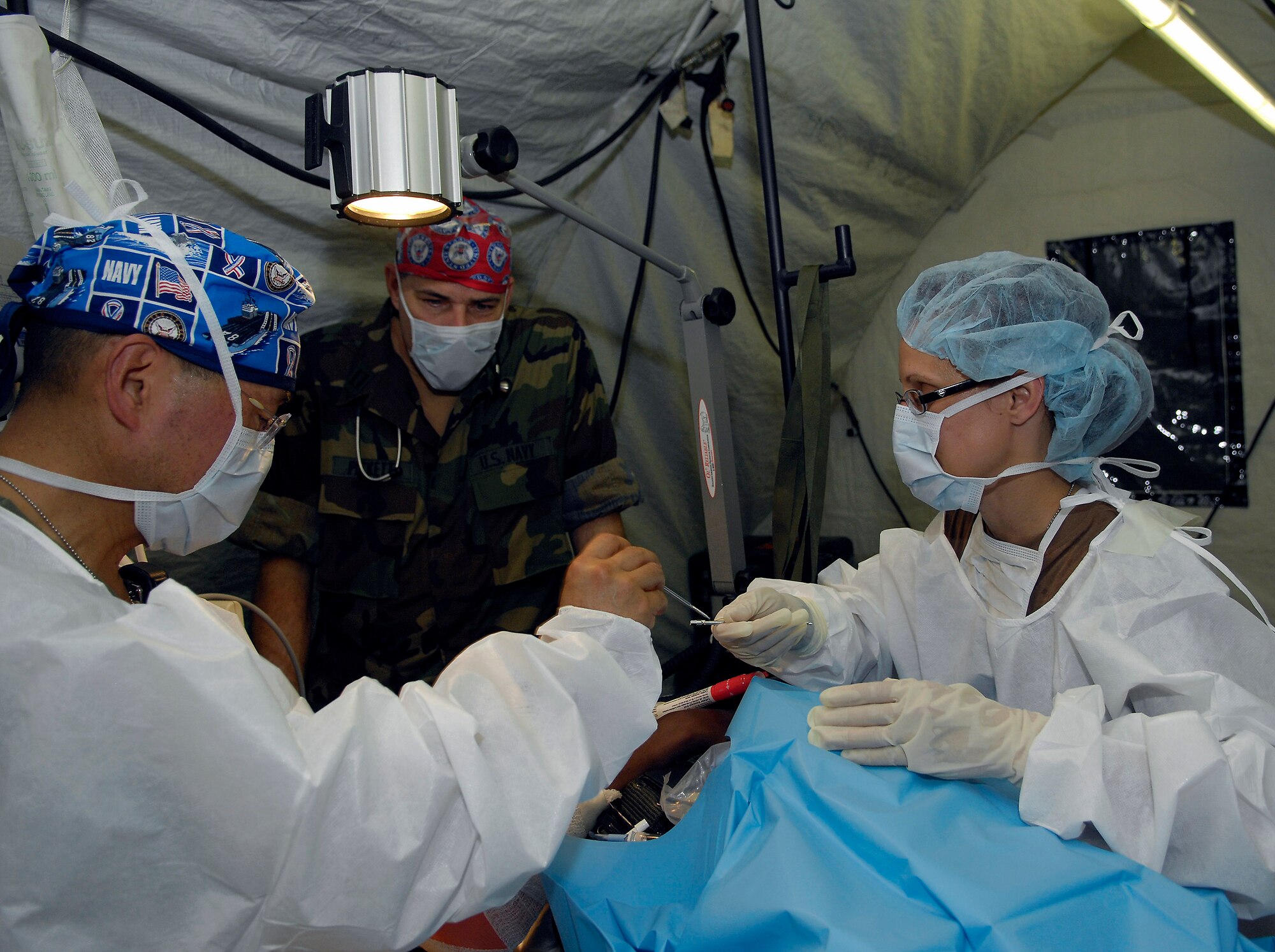 Lt. Cmdr. Terry Lein passes Capt. William Oh a pin to insert in a  simulated broken arm during a mass casualty training exercise July 18 in Bamako, Mali. More than 90 servicemembers deployed for MEDFLAG 08, a multi-national medical training exercise designed to enhance medical capabilities and readiness for U.S. and African Forces. Captain Oh is deployed from Naval Operational Support Unit, Toledo, Ohio. Commander Lein is deployed from the Operational Hospital Support Unit, Camp LeJeune HQ, N.C. (U.S. Air Force photo/Senior Airman Michael S. Dorus) 