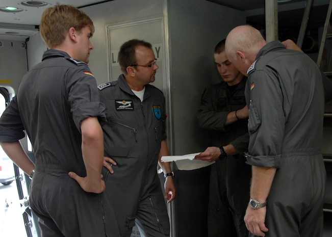 Staff Sgt. Jeff Harmon briefs German Air Force aircrew members on a C-17 on the Charleston AFB flightline July 21. A German general visited Charleston AFB for an orientation of the C-17 and to gain greater knowledge of the capabilities of the aircraft. Sergeant Harmon is a loadmaster with the 14th Airlift Squadron. (U.S. Air Force photo/Airman 1st Class Katie Gieratz)