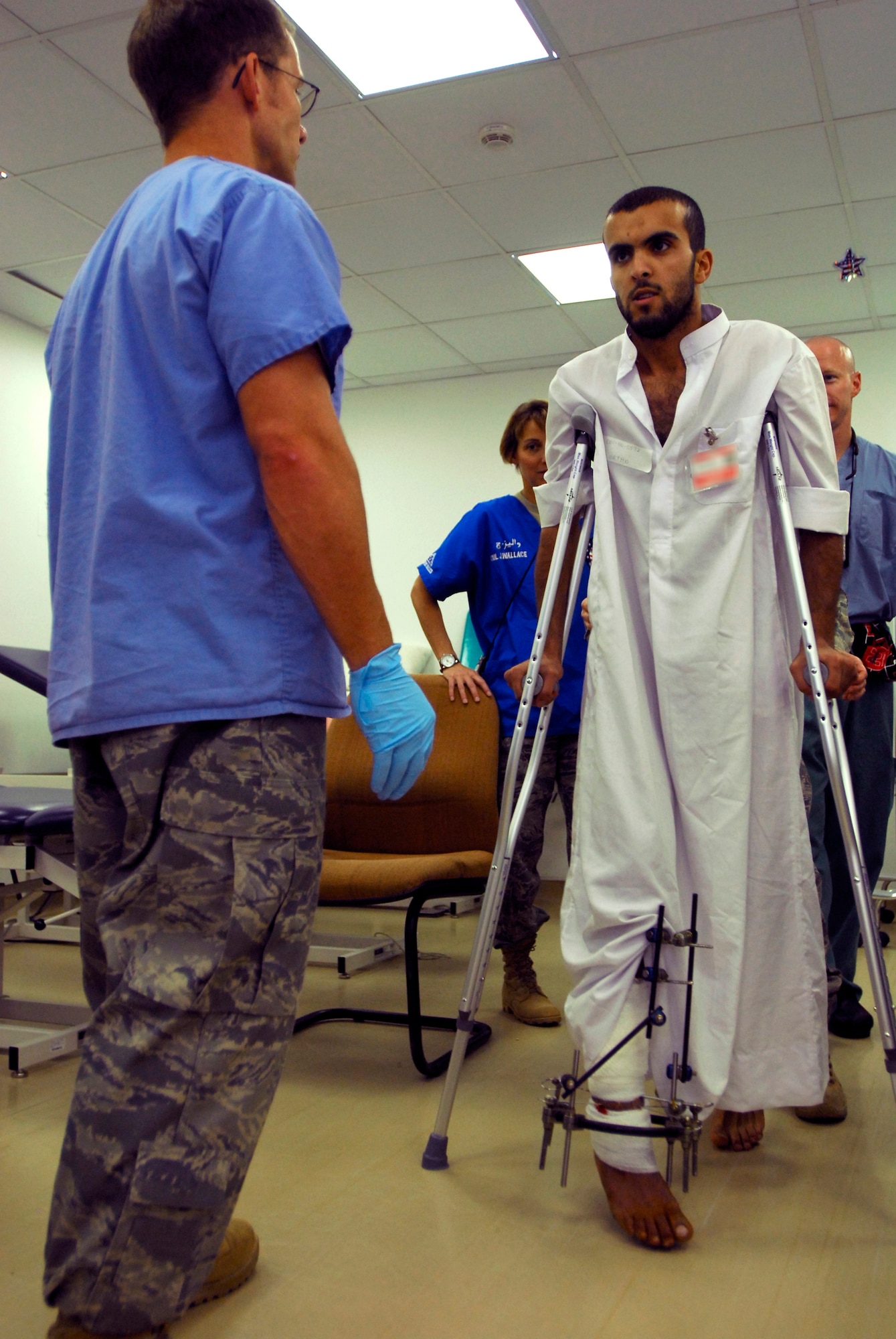 JOINT BASE BALAD, Iraq -- Moqdad walks on crutches toward Tech. Sgt. Daniel Wilson during a physical therapy appointment at the Air Force Theater Hospital here July 22. An external fixator attached to the Iraqi patient's right leg helps keep his bones in place so that his leg will heal properly. Sergeant Wilson, a physical medicine therapist with the 332nd Expeditionary Medical Operations Squadron here, is deployed from Hill Air Force Base, Utah. (U.S. Air Force photo/Airman 1st Class Jason Epley)