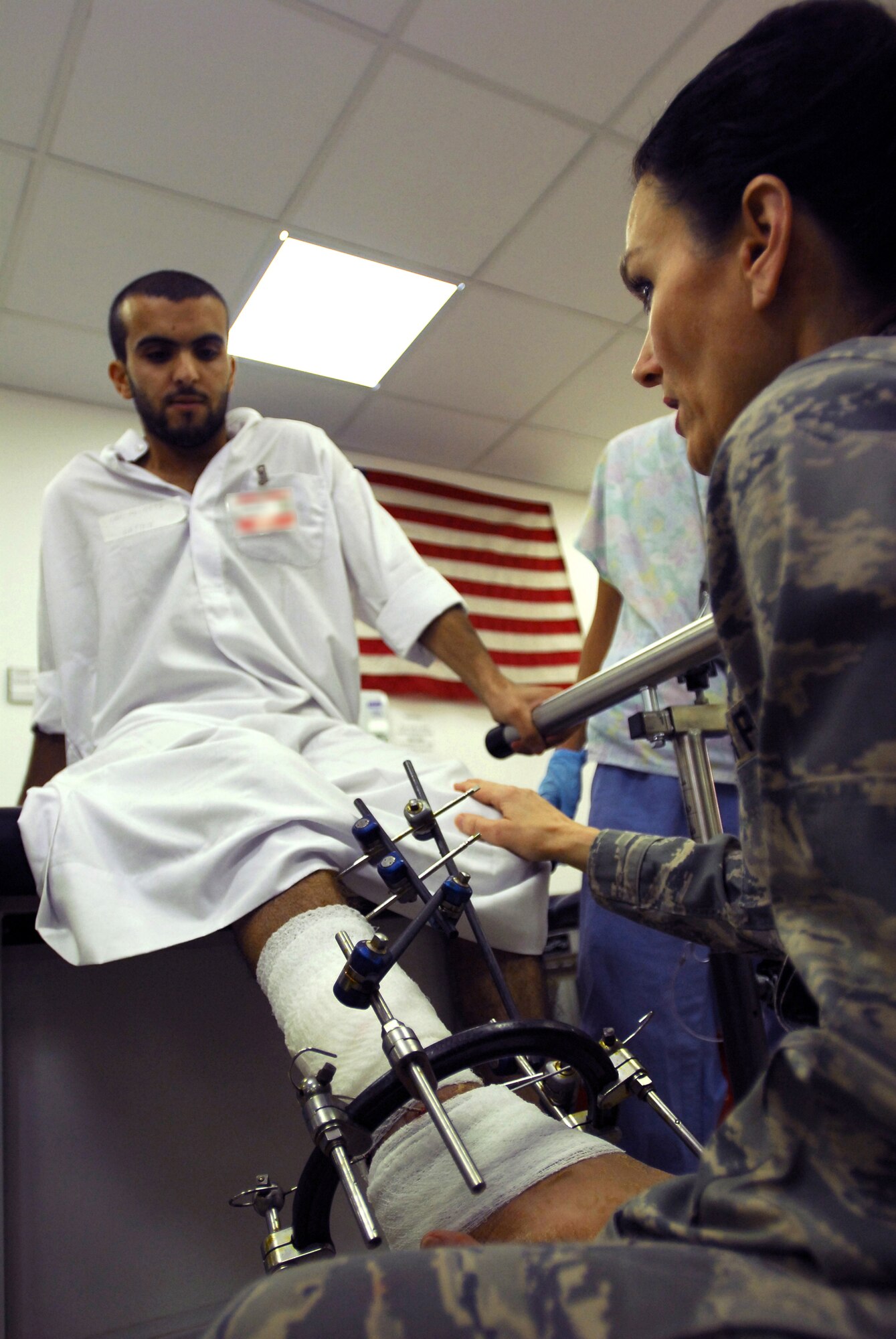 JOINT BASE BALAD, Iraq -- Lt. Col. Lisa Smith helps lower Iraqi local Moqdad's leg, which was shattered two months ago, before helping him take his first steps in two weeks during a physical therapy appointment at the Air Force Theater Hospital here July 22. The Occupational Therapy and Physical Therapy Clinic provides care to Iraqi patients twice a week. Colonel Smith, the element chief of occupational and physical therapy for the 332nd Expeditionary Medical Operations Squadron, is deployed from Lackland Air Force Base, Texas. (U.S. Air Force photo/Airman 1st Class Jason Epley)