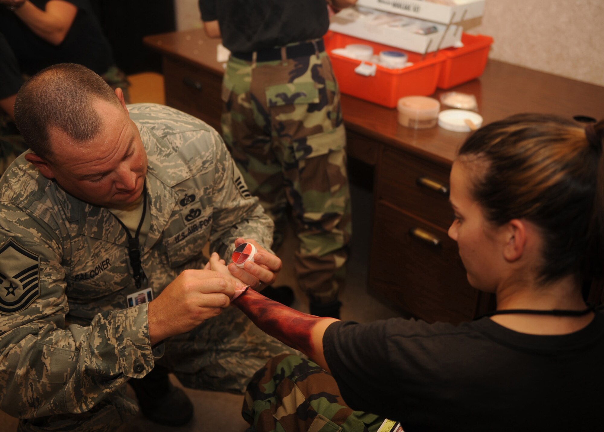 SEYMOUR JOHNSON AIR FORCE BASE, N.C. -  Master sergeant Brian Falconer, 4th Plans and Evaluations office, applies a moulage of cuts and burns to Airman Basic Jillian Livingston as part of a munitions major accident response exercise here, July 21. The purpose of the MARE is to exercise first responder?s timely reaction in the event of a real world situation.(U.S. Air Force photo by Airman 1st Class Ciara Wymbs)