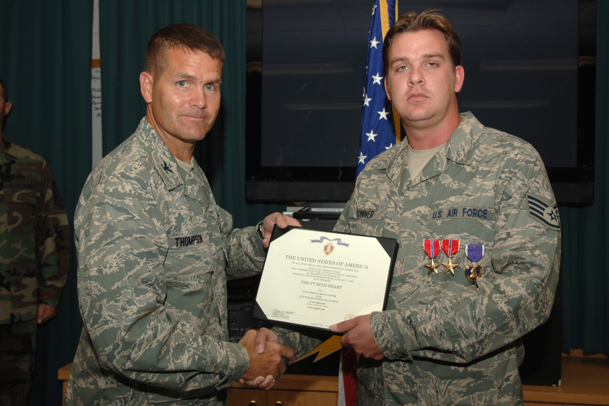 Col. Bradley Thompson, 720th Special Tactics Group commander, presents Staff Sgt. Dean Conner, 23rd Special Tactics Squadron, with the certificate to accompany the Purple Heart during a ceremony here July 21. The combat controller was also awarded two Bronze Star Medals, one with Valor, for his heroic actions during a hostile fire situation. During a hail of incoming enemy gunfire, Sergeant Conner suffered a gunshot wound. He continued to return fire and call in support from above, despite his injury. (U.S. Air Force photo by Senior Airman Emily Moore)