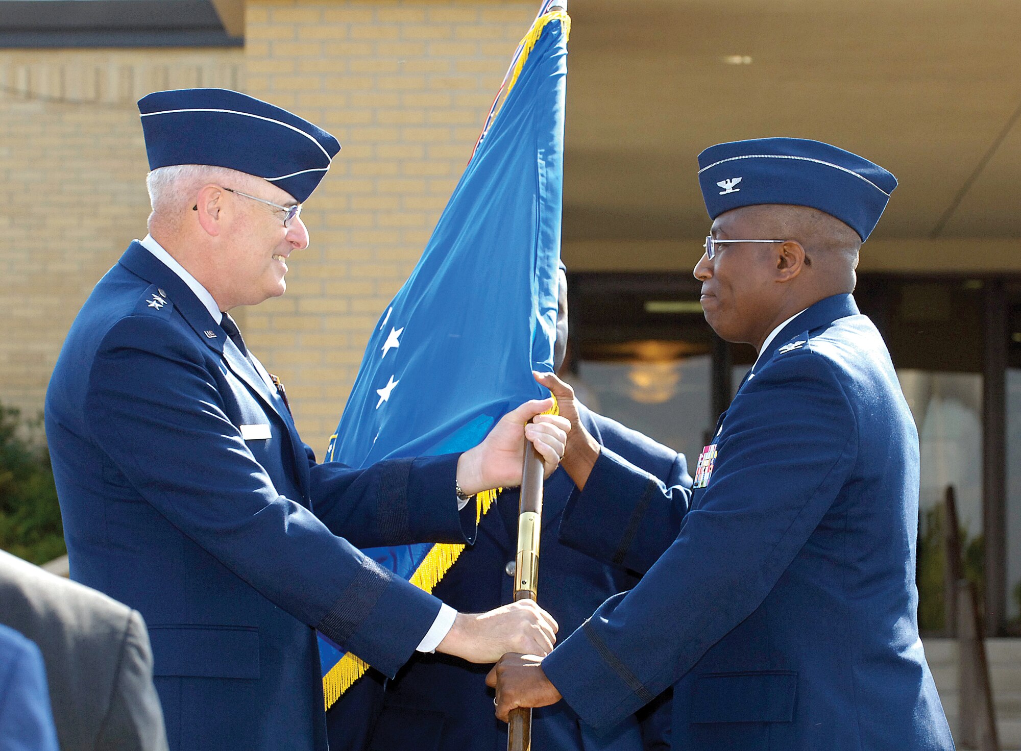 In a time honored military tradition,  Maj. Gen. Loren Reno passes the 72nd Air Base Wing guidon to Col. Allen Jamerson July 18, signifying transfer of leadership during the wing’s change of command ceremony at Tinker.(Air Force photo/Margo Wright)